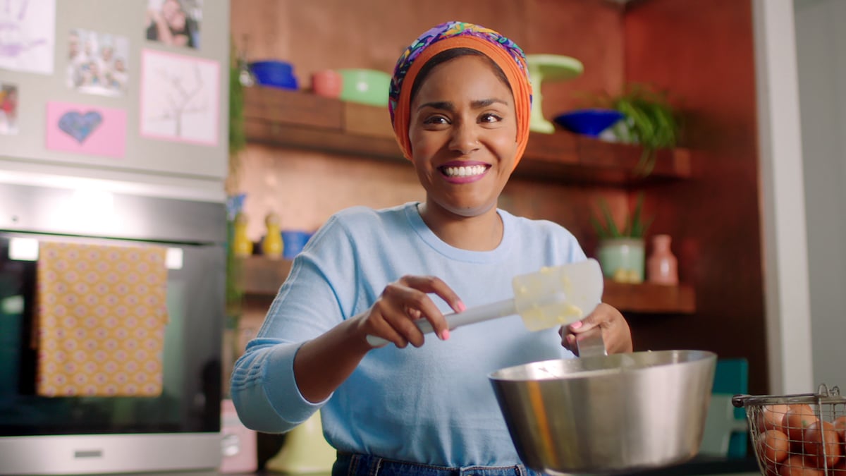 Nadiya Hussain smiles as she holds a spatula on 'Nadiya Bakes'