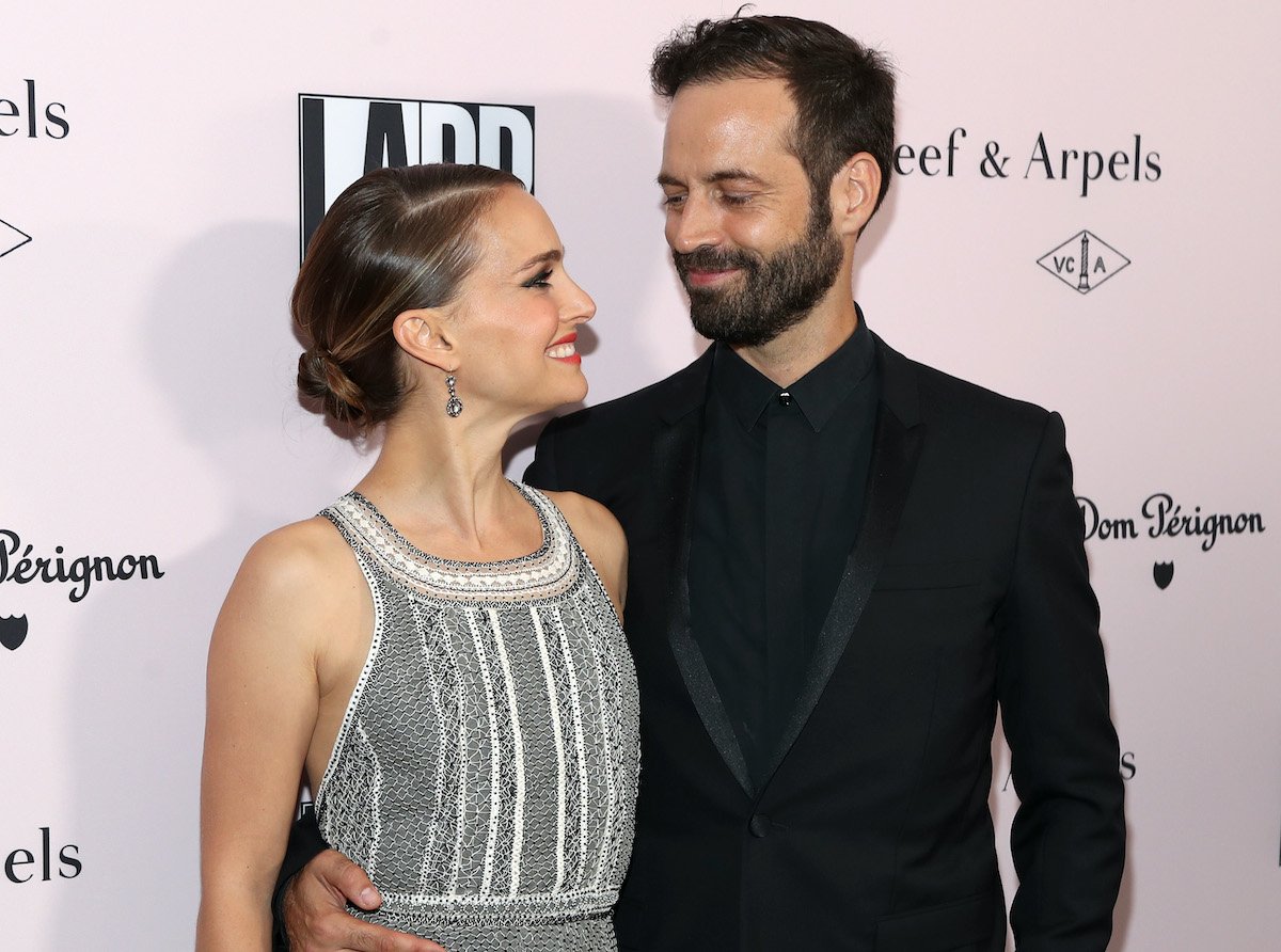 Natalie Portman and Benjamin Millepied look at each other and smile on a red carpet | Jerritt Clark/Getty Images for Dom Pérignon
