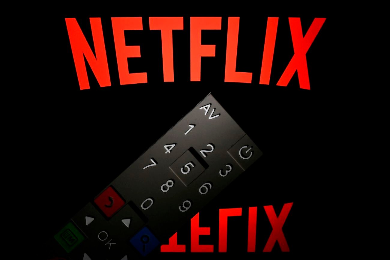 Netflix logo displayed on a tablet screen with a remote control in front of it.