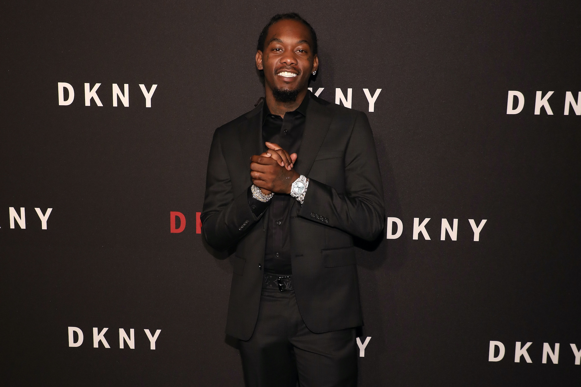 Offset smiling in front of a dark gray background