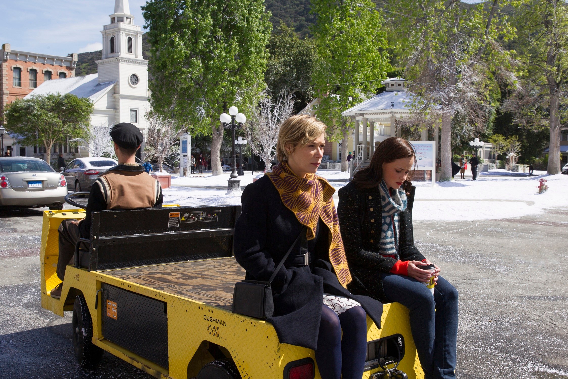 Paris Geller and Rory Gilmore ride through Stars Hollow on the back of a golf cart in 'Gilmore Girls: A Year in the Life' 