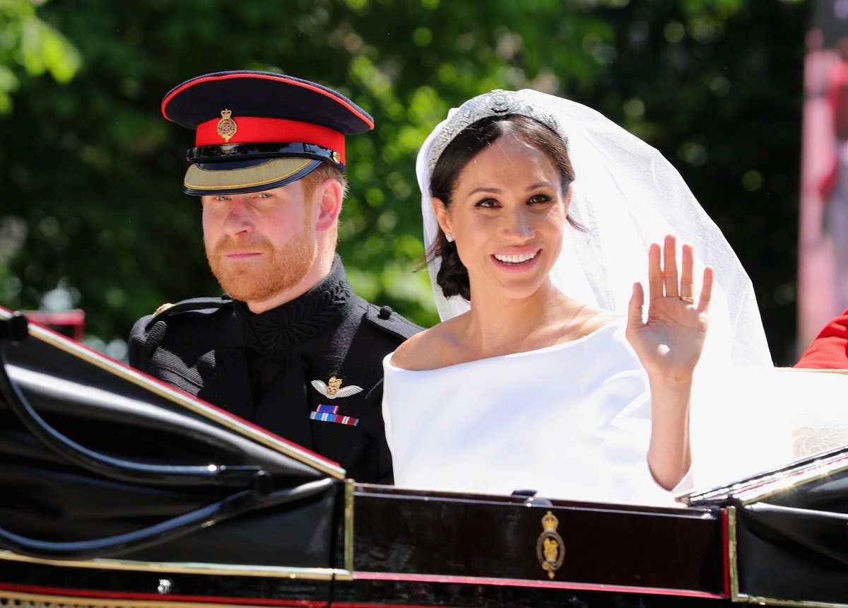 Prince Harry, Duke of Sussex and Meghan, Duchess of Sussex leave Windsor Castle in the Ascot Landau carriage during a procession after getting married at St Georges Chapel on May 19, 2018 in Windsor, England