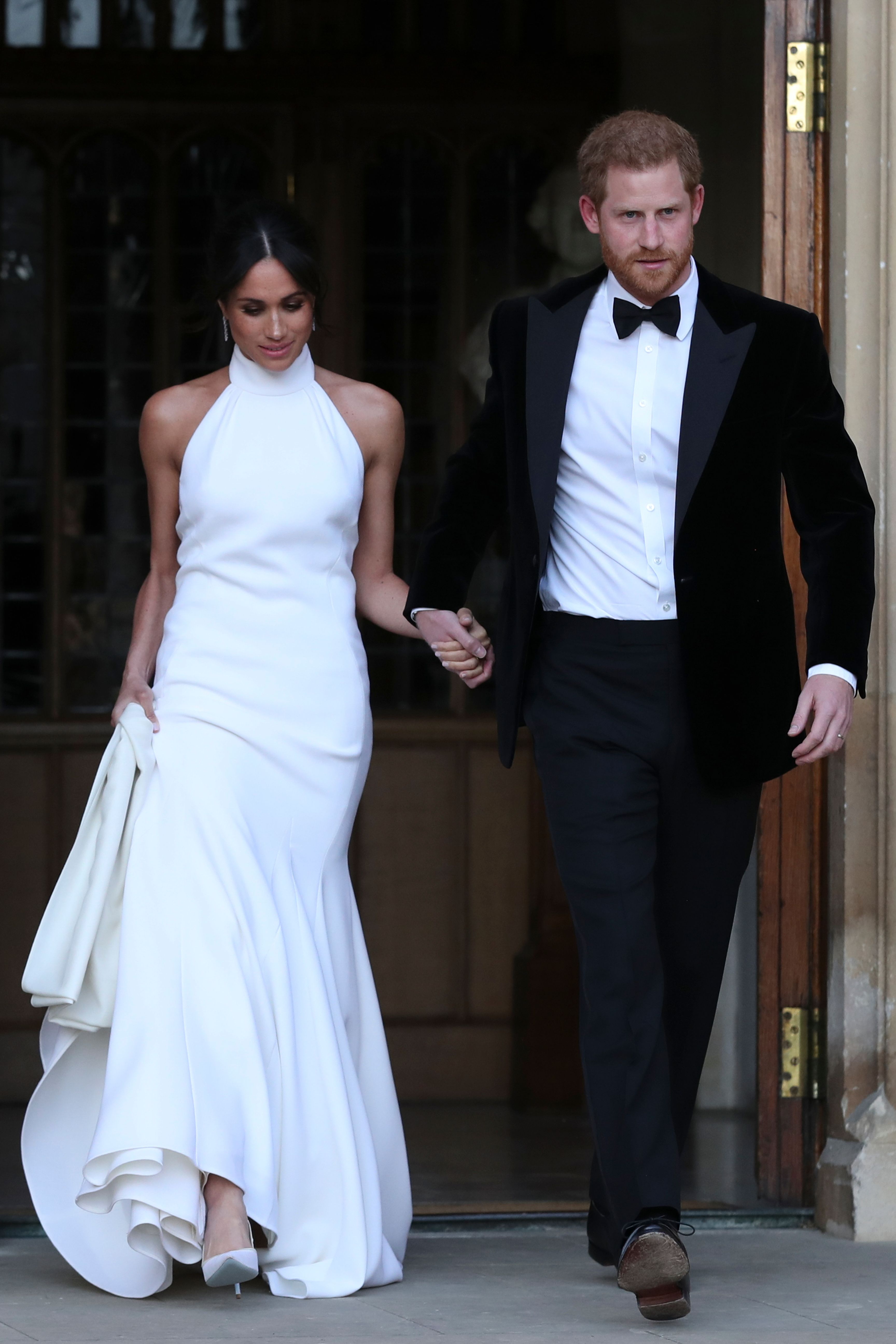 Prince Harry and Meghan Markle walking out of Windsor Castle and headed to evening reception
