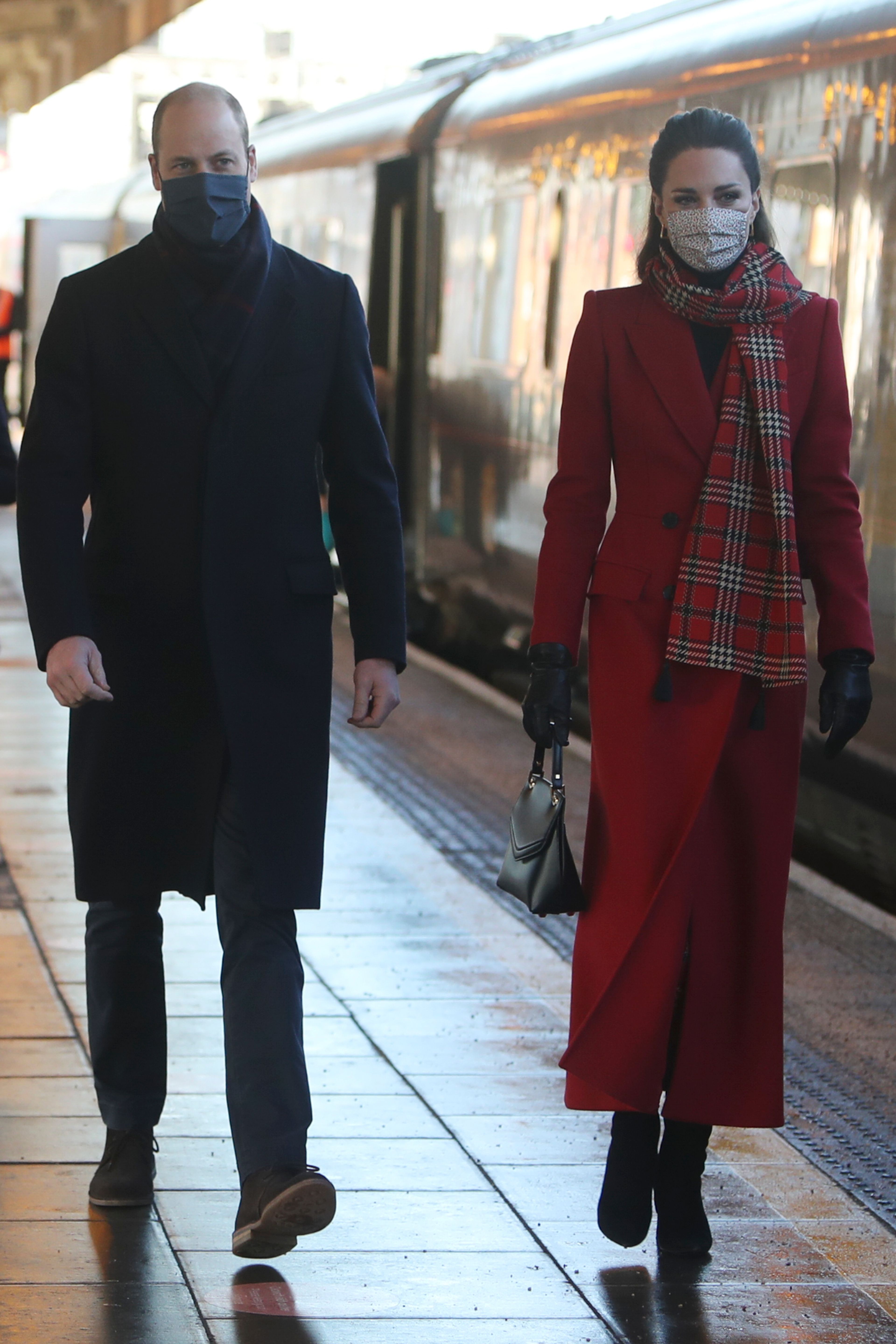 Prince William and Kate Middleton wearing masks and walking alongside eachother as they arrive at Cardiff Central train station in South Wales on Dec. 8, 2020
