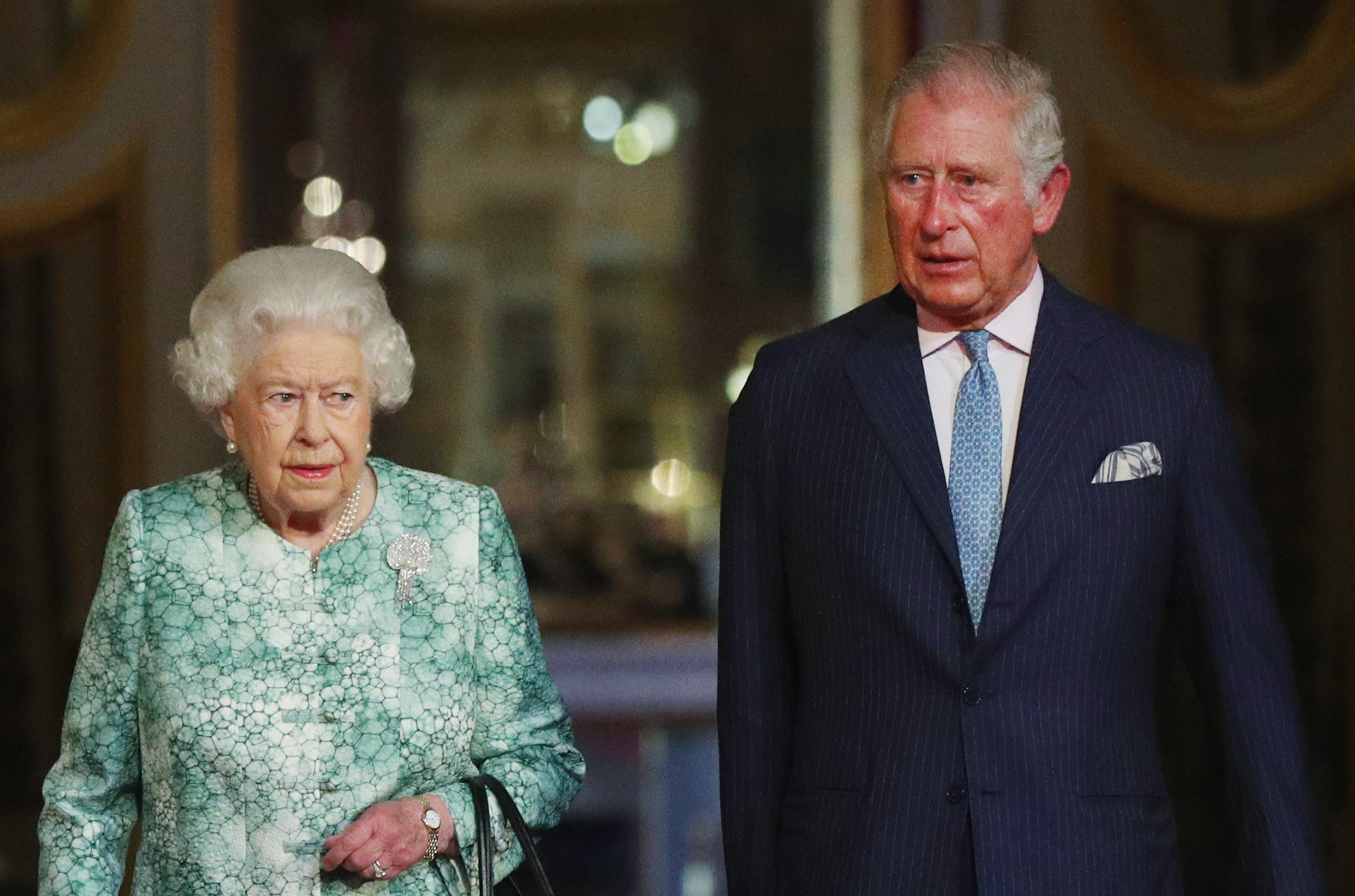 Queen Elizabeth II and Prince Charles walking together in Buckingham Palace to attend a formal government meeting