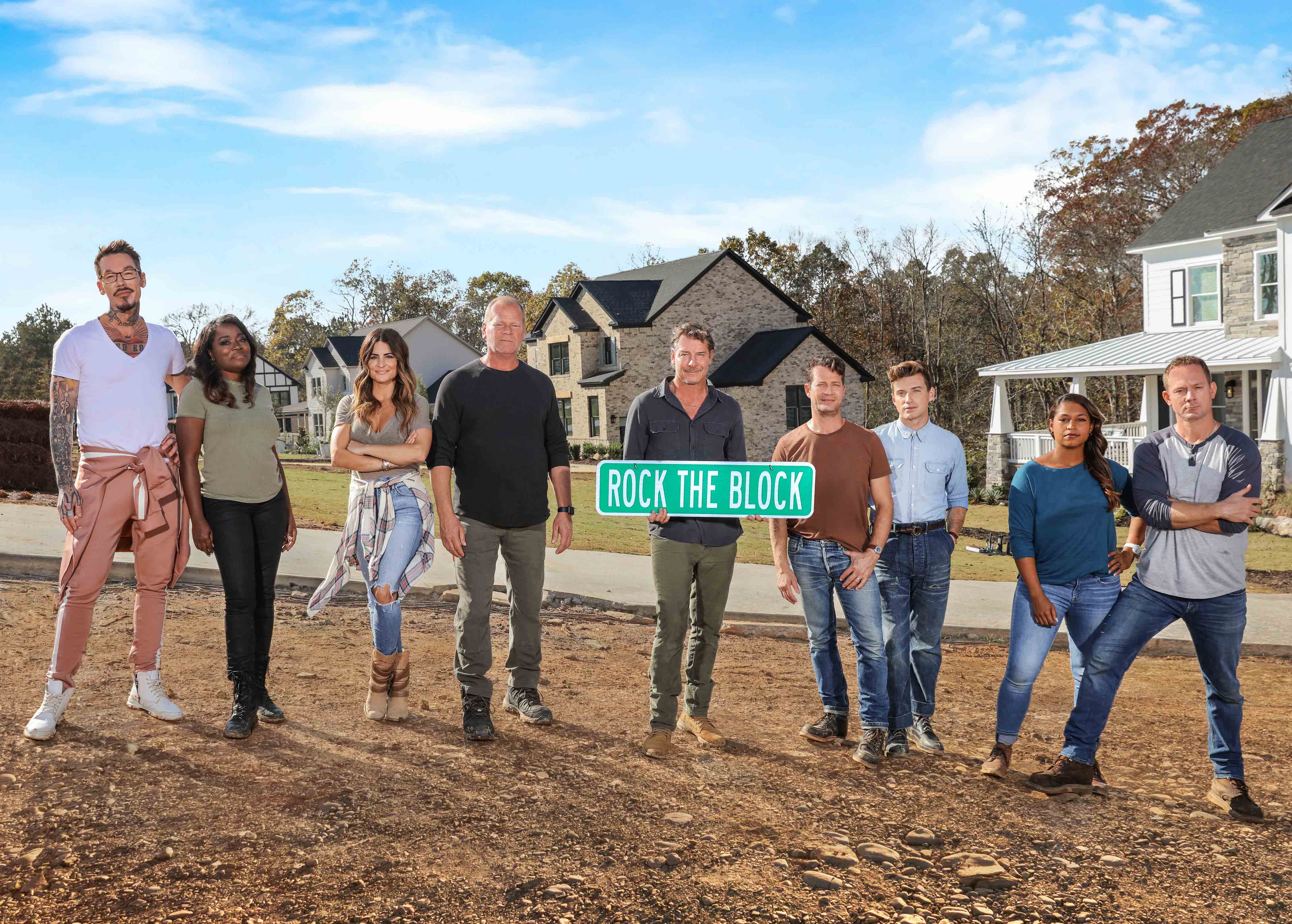 As seen on HGTV’s Rock the Block season 2, the cast and host Ty Pennington poses with the houses in the background.