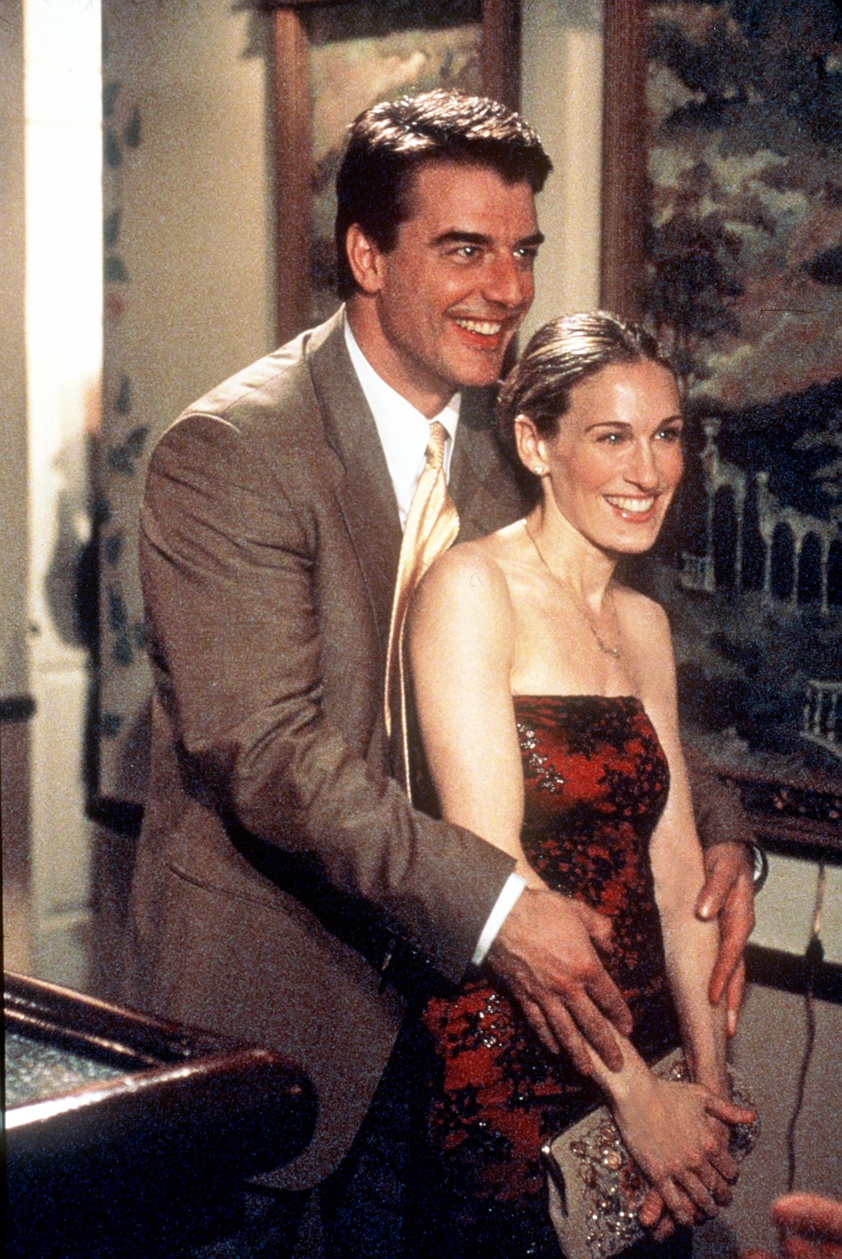 Chris Noth, as Mr. Big, hugs Sarah Jessica Parker as Carrie Bradshaw, from behind in a season 2 scene from 'Sex and the City' 