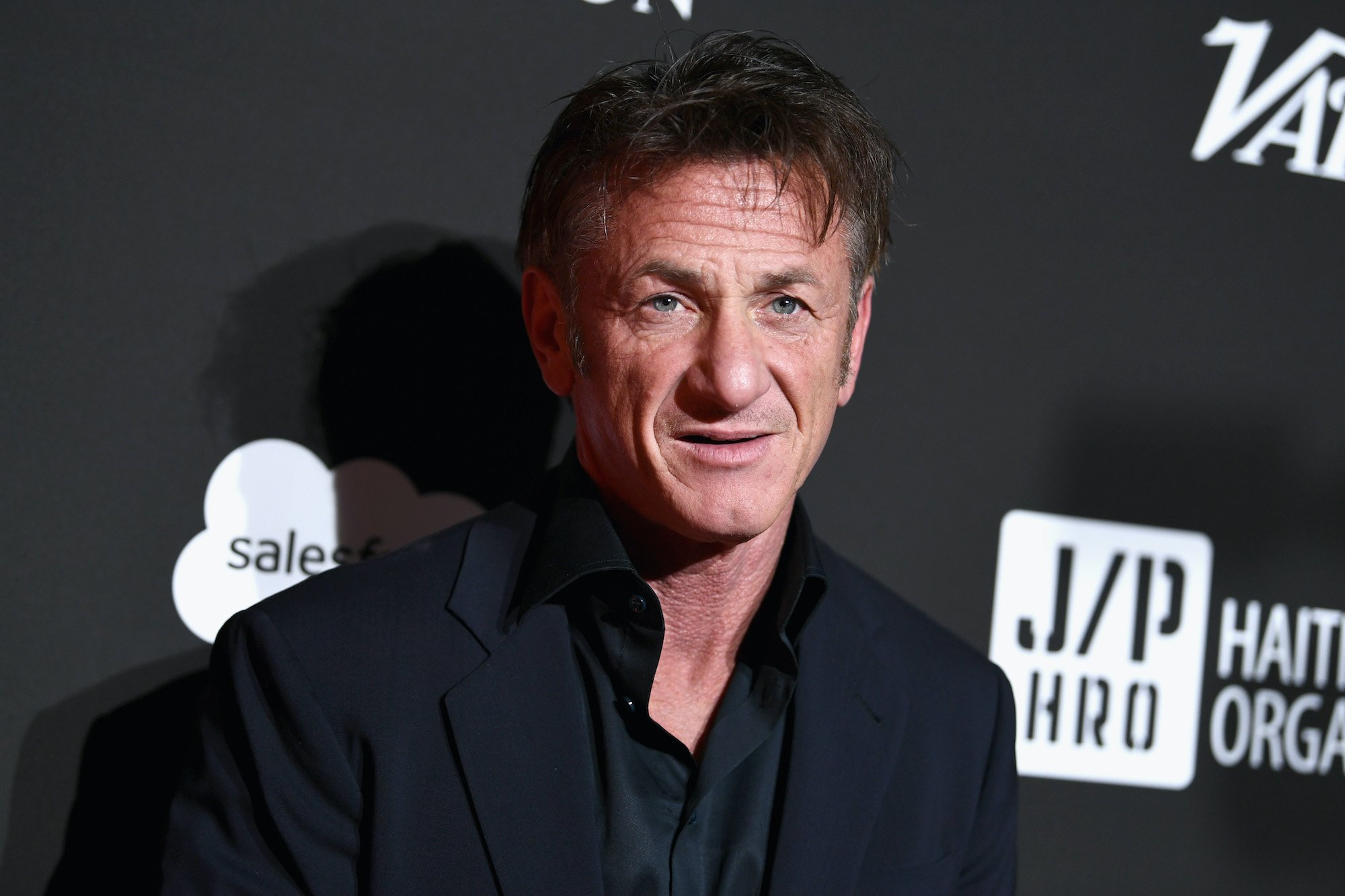 Sean Penn standing in front of a gray background