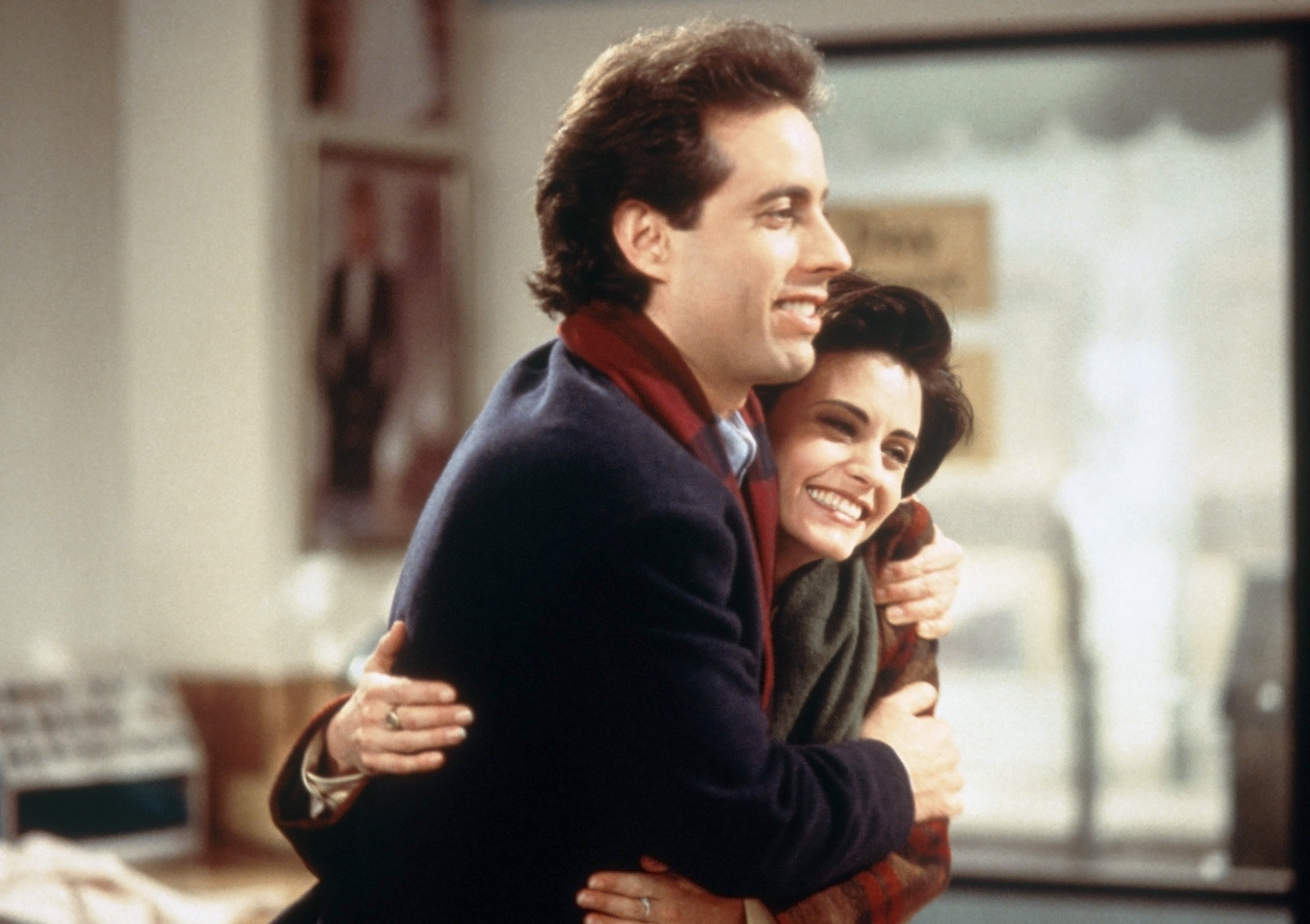 Jerry Sienfeld as Jerry and Courteney Cox as Meryl stand in a dry cleaners during a scene for 'Seinfeld'