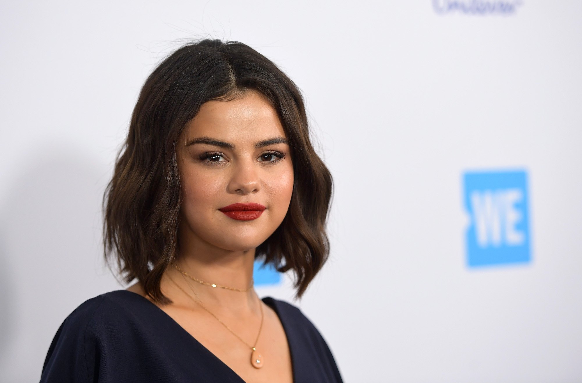 Selena Gomez smiling in front of a white background