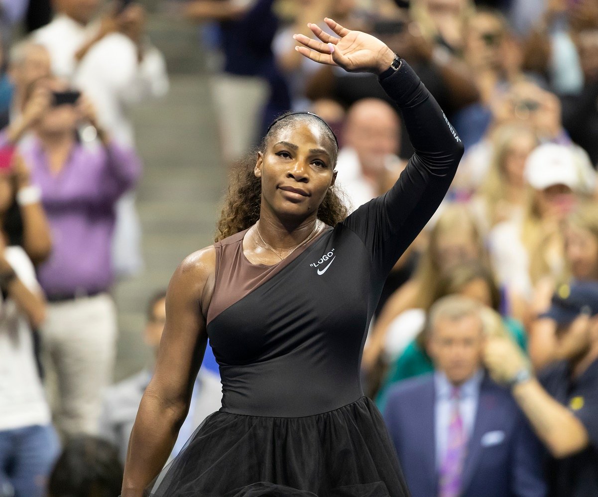 Serena Williams waves to the crowd from the court after celebrating US Open victory
