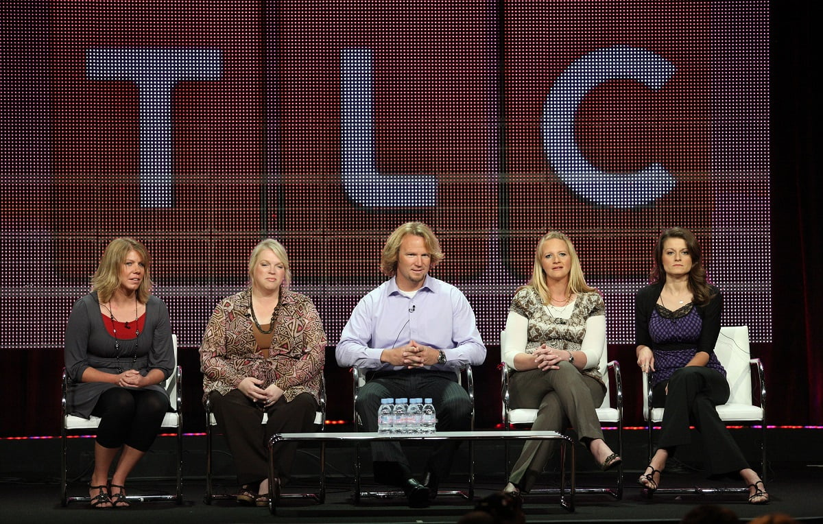 Meri, Janelle, Kody, Christine, and Robyn Brown of 'Sister Wives' sitting on a panel in front of a giant TLC logo during the Summer TCA Press Tour in 2010