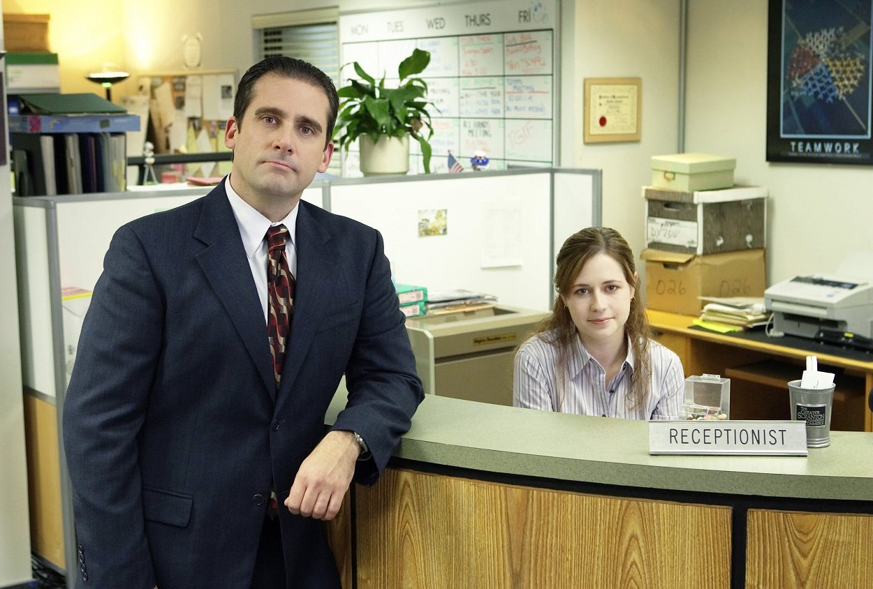 The Office stars Steve Carell and Jenna Fischer pose as their characters by Pam's reception desk