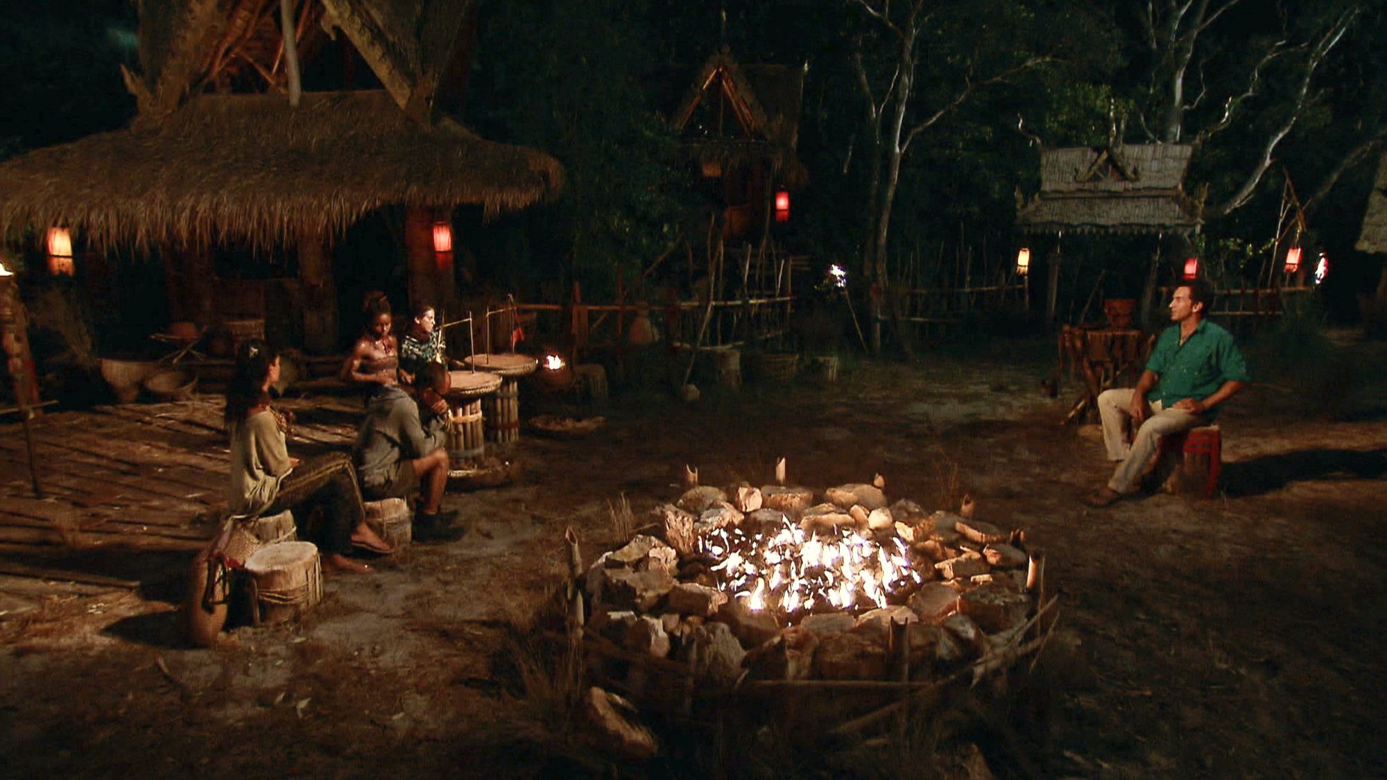 'Survivor' tribal council with contestants to the left, a fire pit in the middle, and Jeff Probst to the right