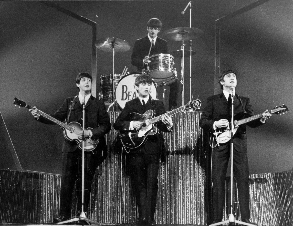 The Beatles perform at the London Palladium with Ringo Starr on drums, rear, and  (L to R): Paul McCartney, George Harrison, and John Lennon on bass guitar, lead guitar, and rhythm guitar, respectively