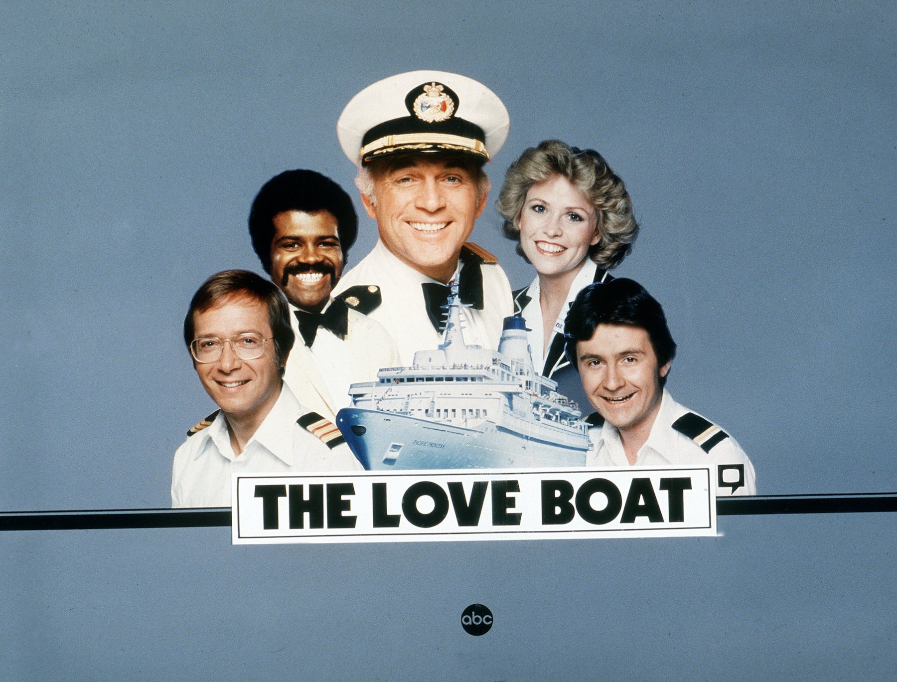 (L-R) Bernie Kopell, Ted Lange, Gavin MacLeod, Lauren Tewes, Fred Grandy behind a love boat logo