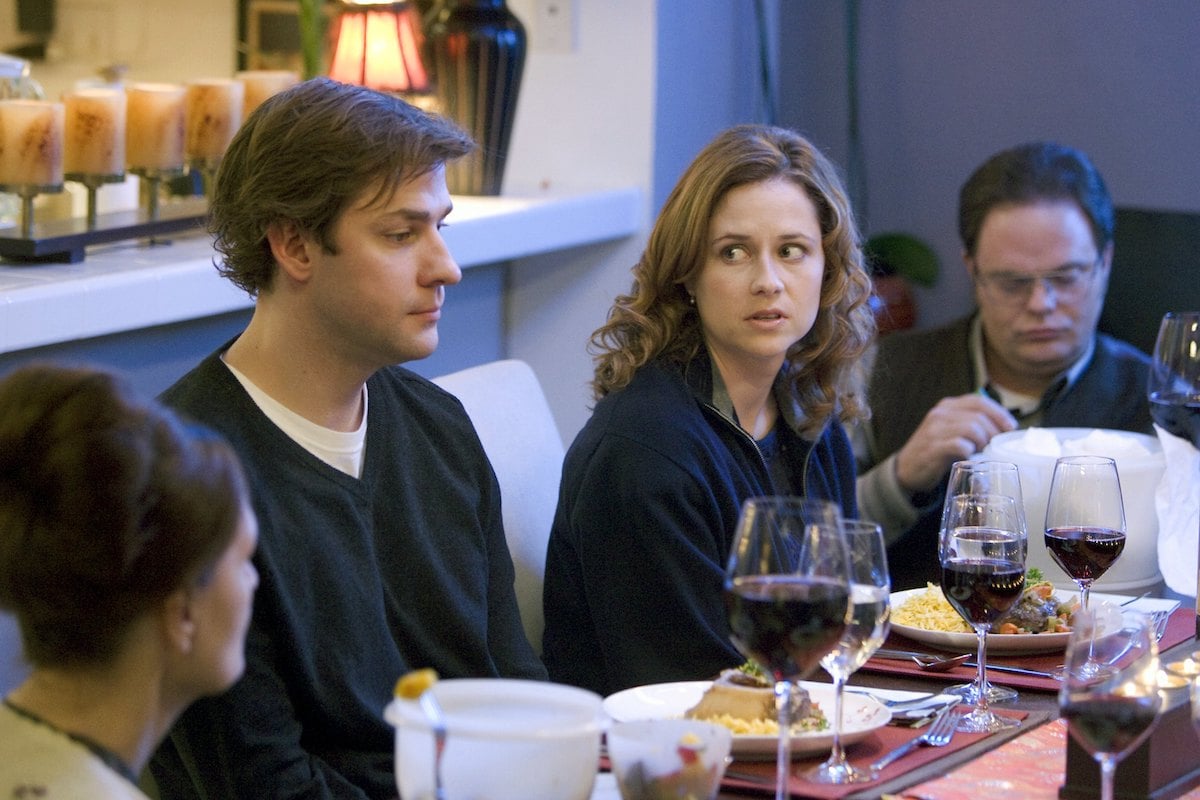 John Krasinski as Jim Halpert, Jenna Fischer as Pam Beesly, Rainn Wilson as Dwight Schrute sit together at a dinner table on 'The Office'