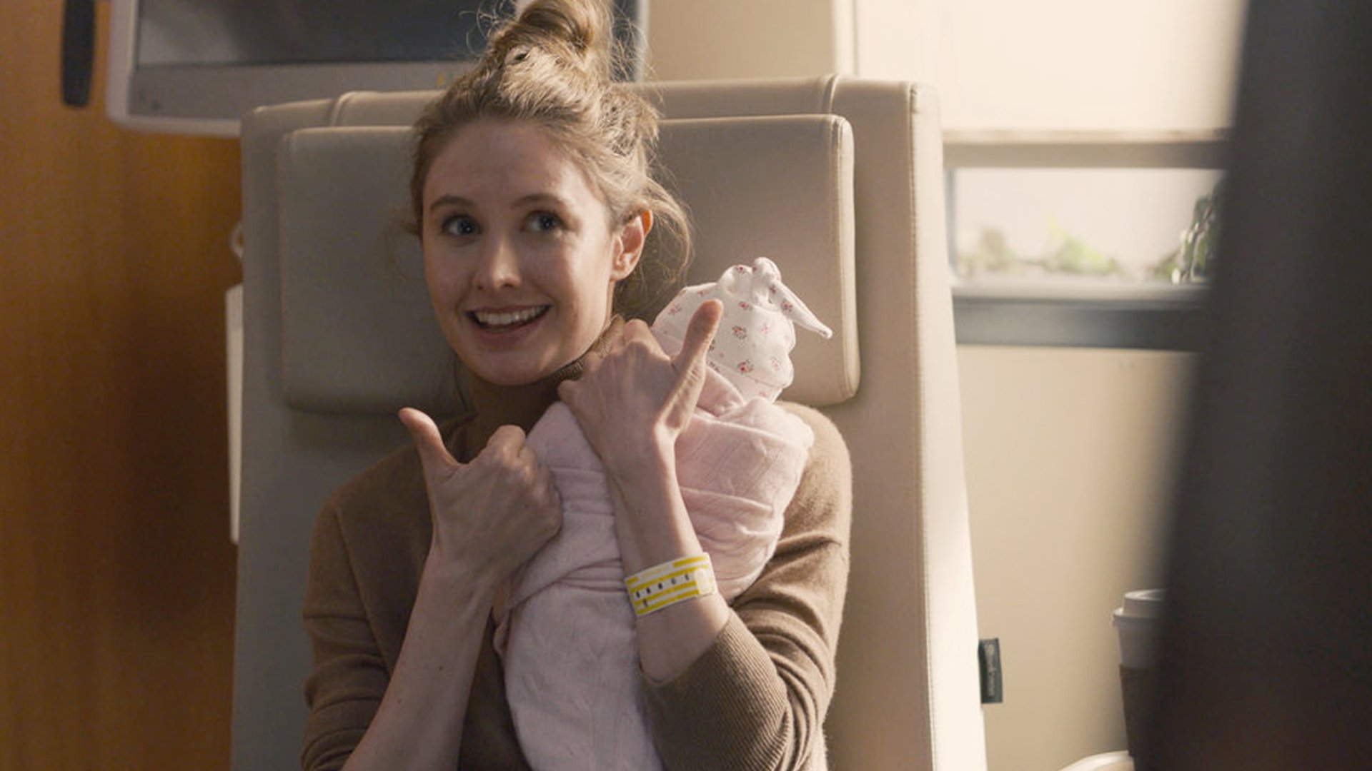 Caitlin Thompson as Madison holding a baby with her thumbs up on ‘This Is Us’ Season 5 Episode 9, ‘The Ride.’
