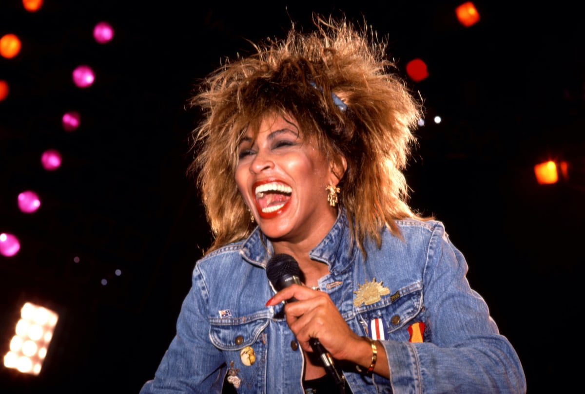 Tina Turner in a denim jacket smiles while she performs during her 1985 'Private Dancer Tour' on August 28, 1985 at the Joe Louis Arena in Detroit, Michigan