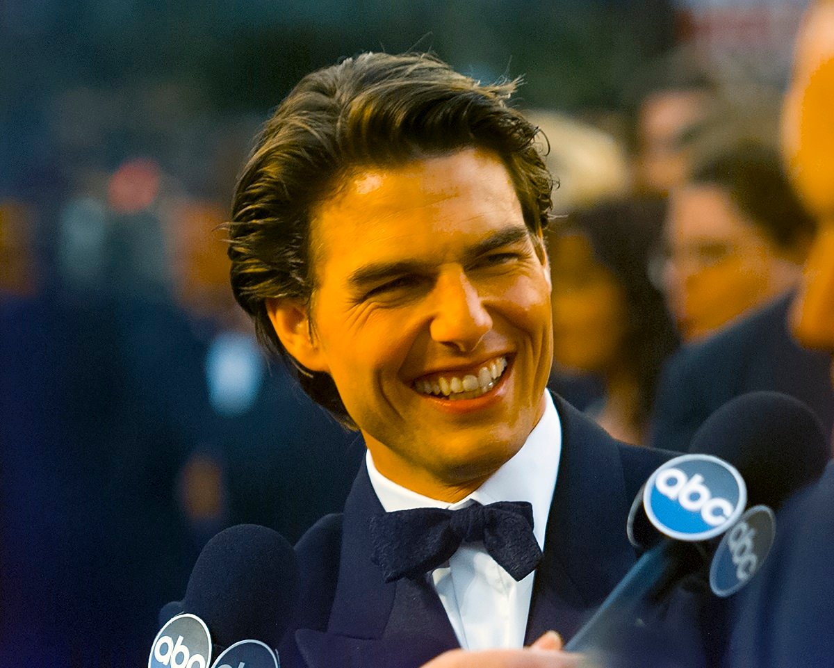 Tom Cruise smiling on the red carpet in 1997