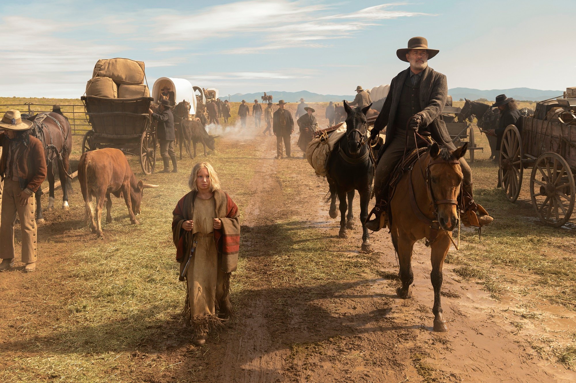 Tom Hank rides a horse while Helena Zengel walks