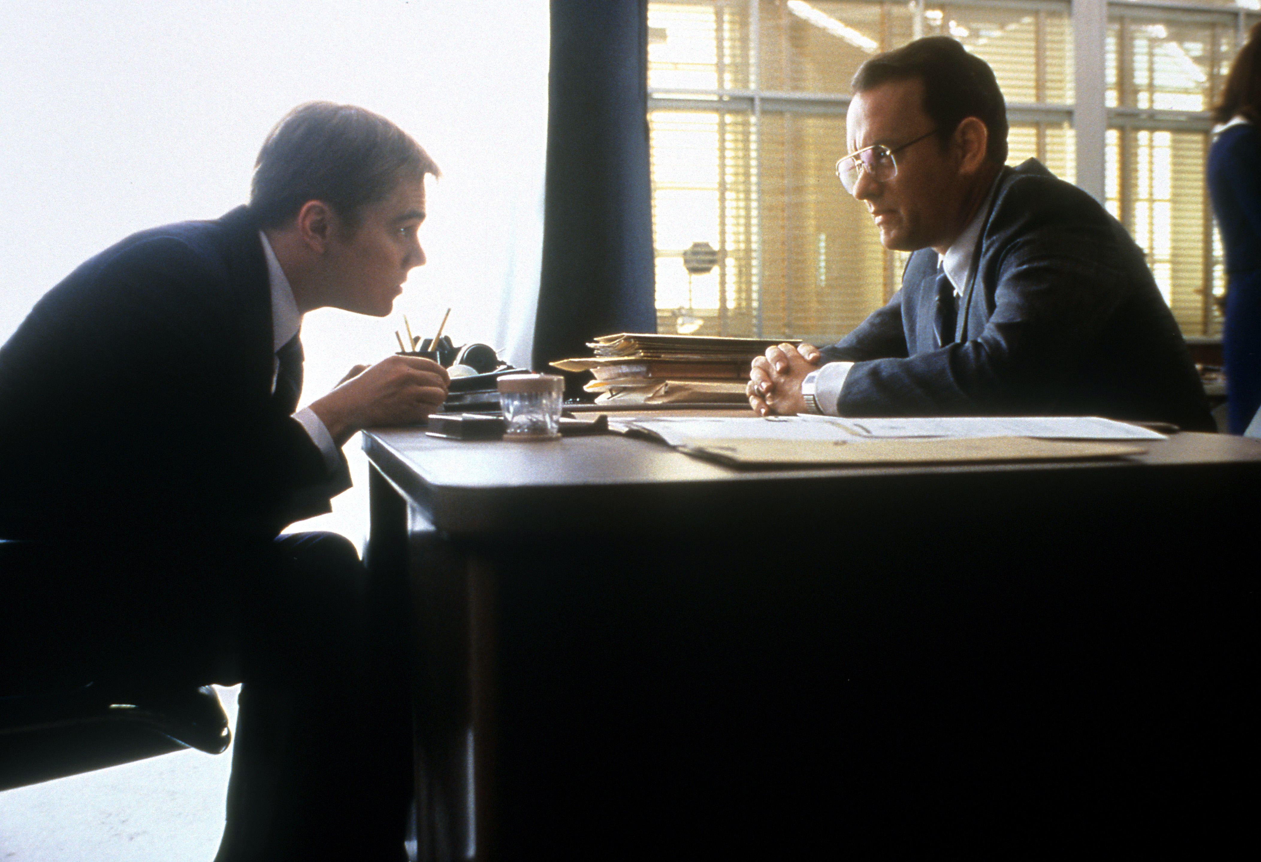 Tom Hanks and Leonardo DiCaprio sit at a desk
