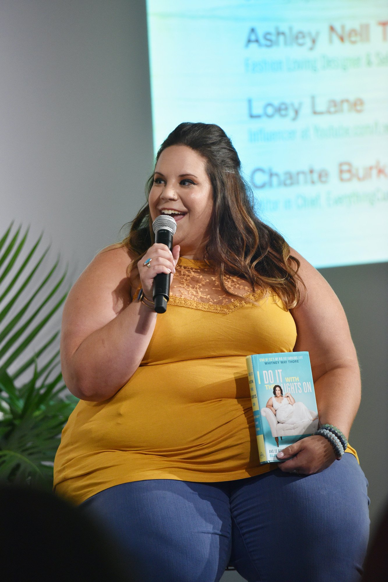 Whitney Way Thore smiling, speaking into a microphone