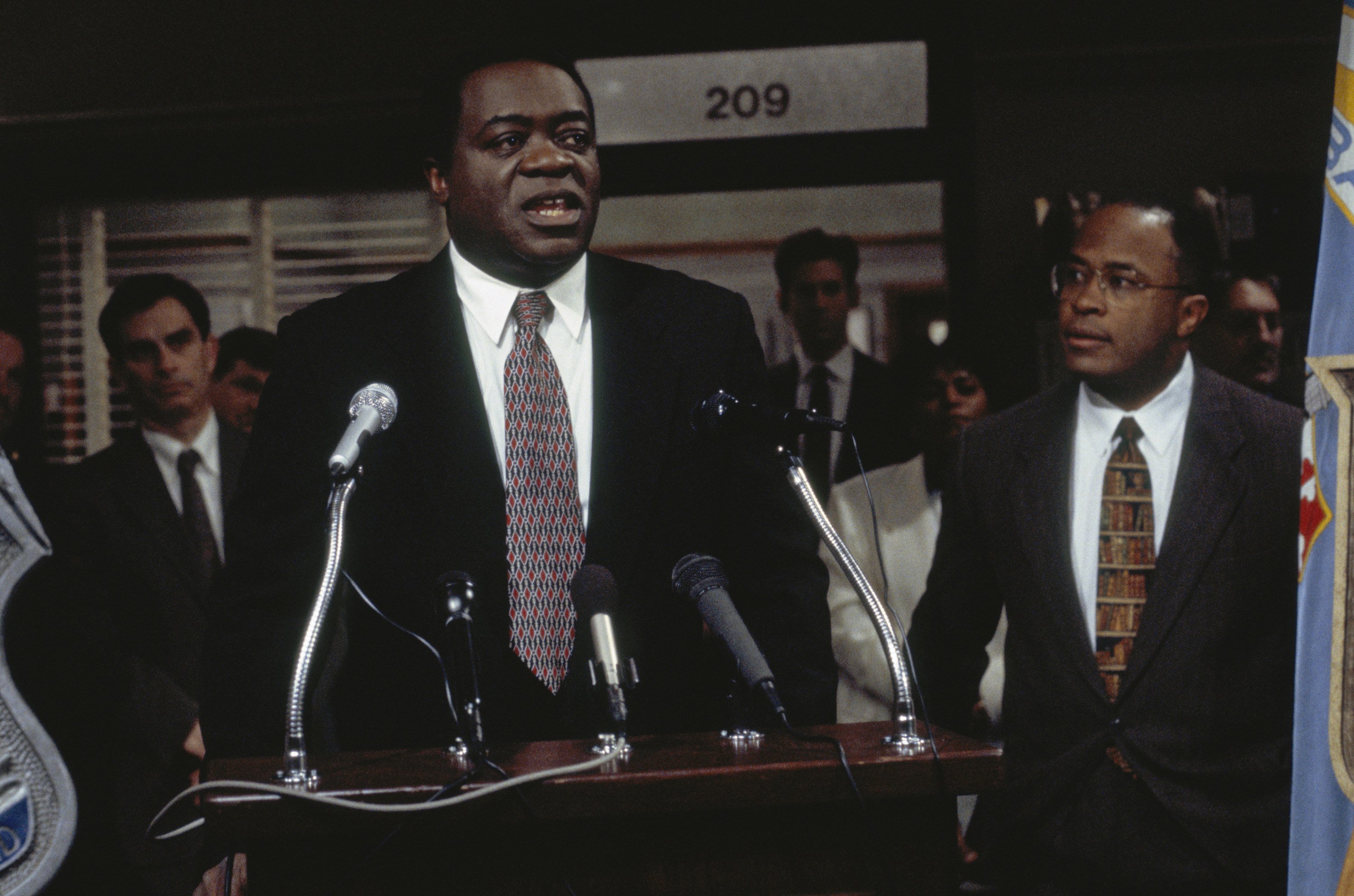 Yaphet Kotto speaks at a podium on Homicide