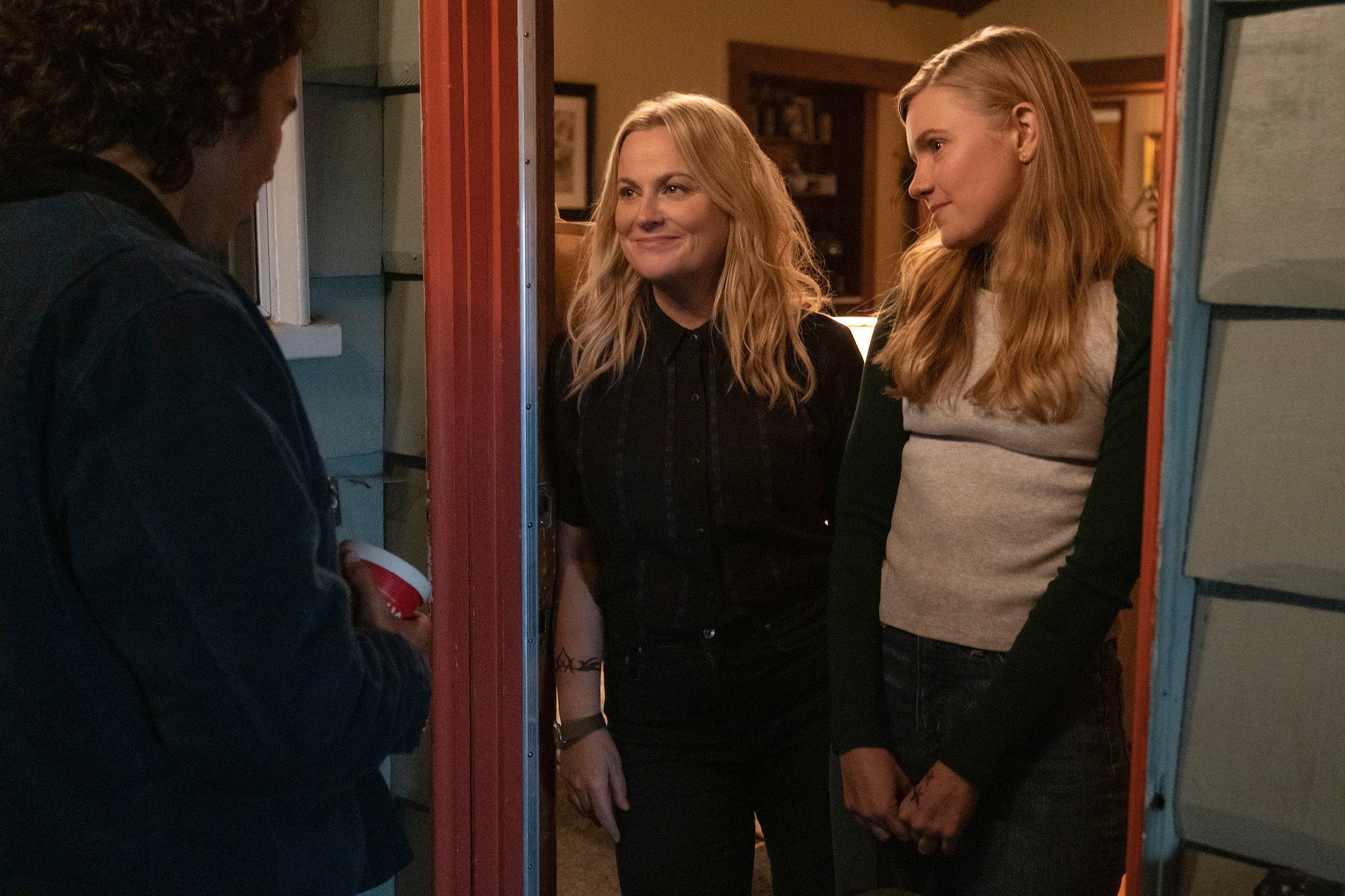 Nico Hiraga as Seth comes to the door as Amy Poehler as Lisa (and Director/Producer) and Hadley Robinson as Vivian answer, 'Moxie' 