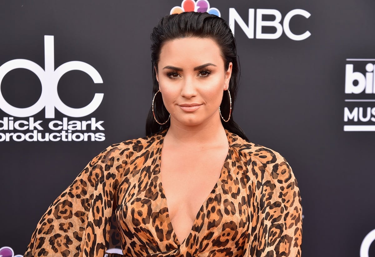 Demi Lovato in a leopard-print dress looking staring straight ahead