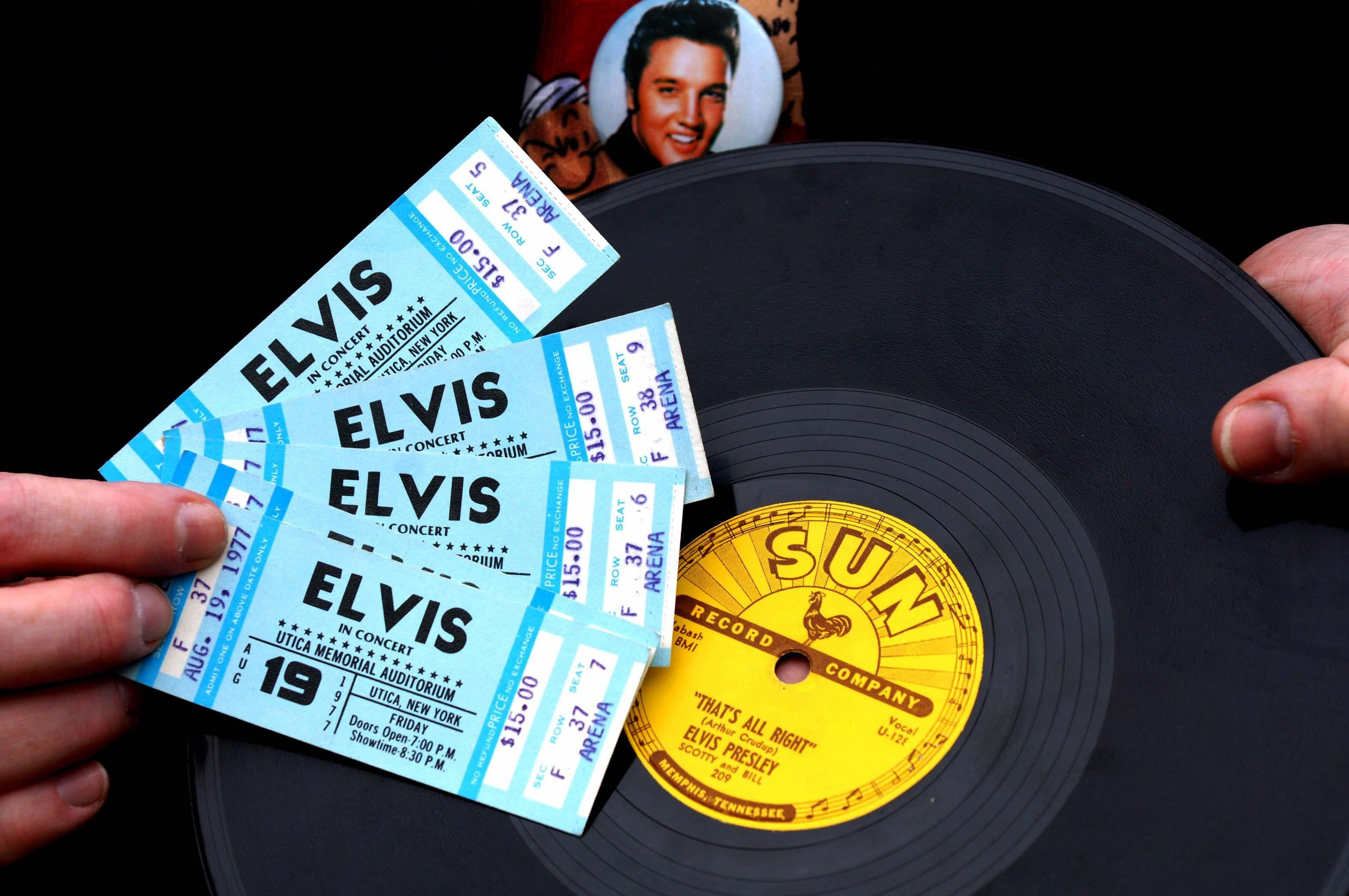 Tickets for an Elvis Presley concert in front of a vinyl record