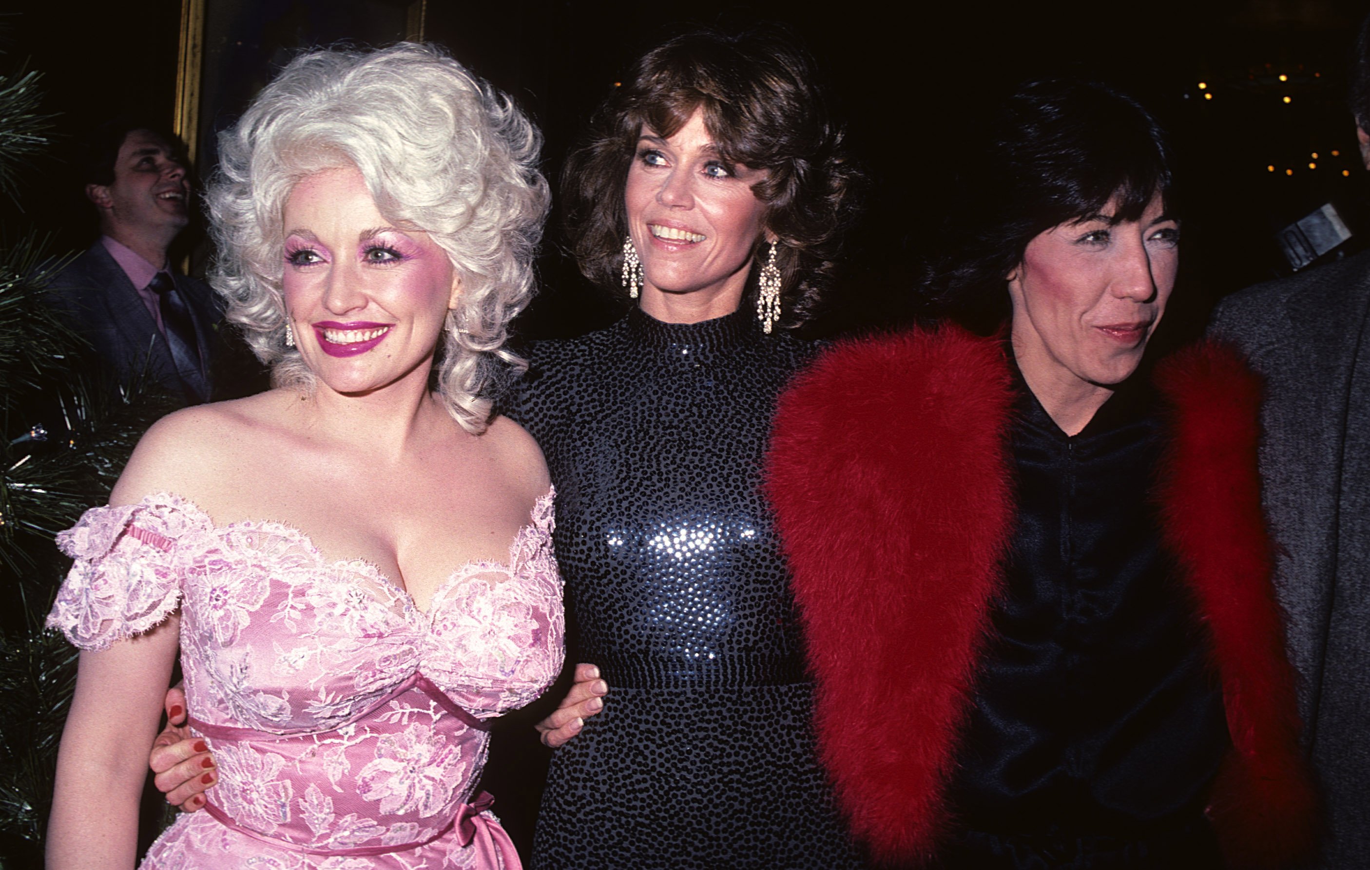 Dolly Parton, Jane Fonda, and Lily Tomlin near other people