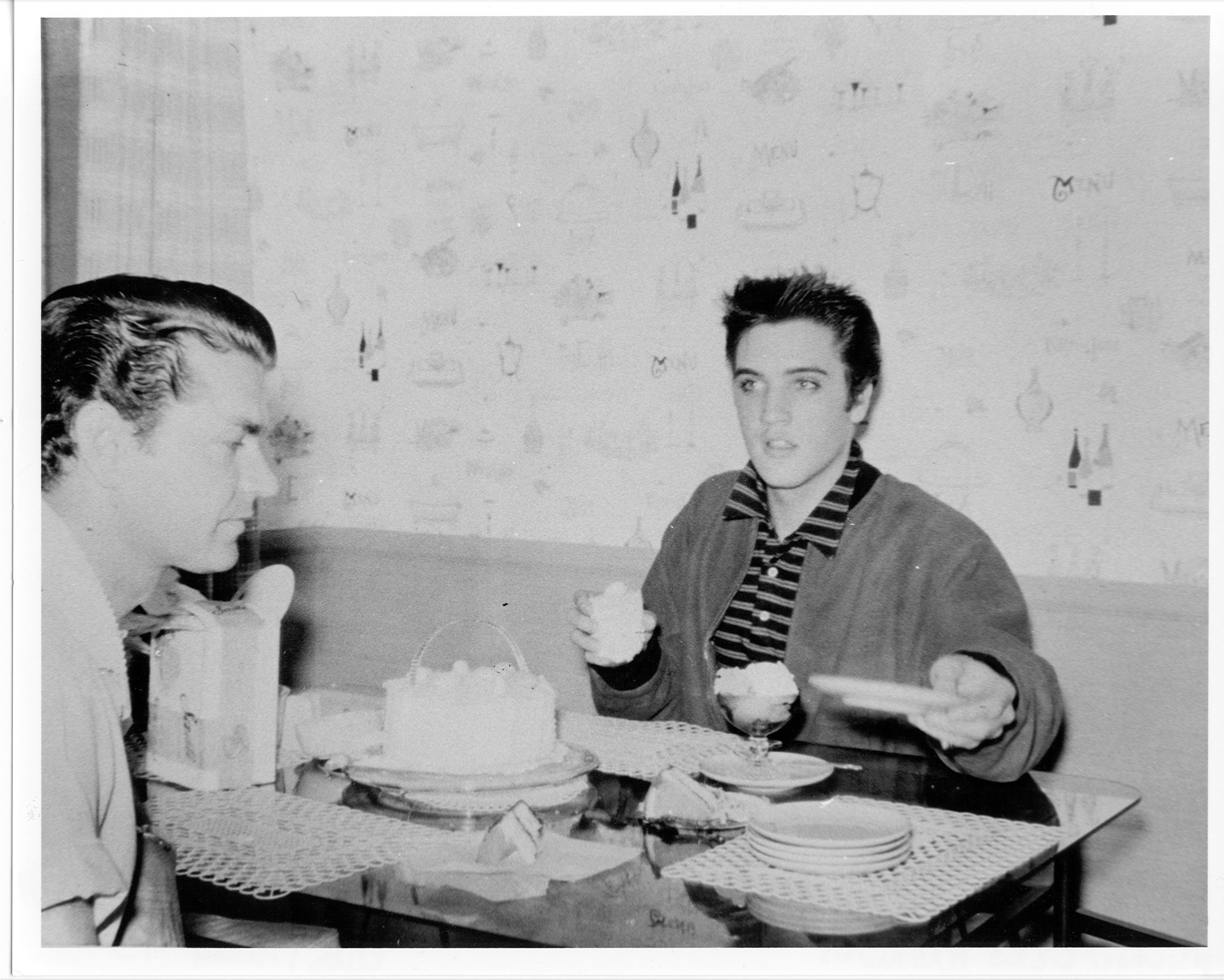 Elvis Presley eating with Sam Phillips