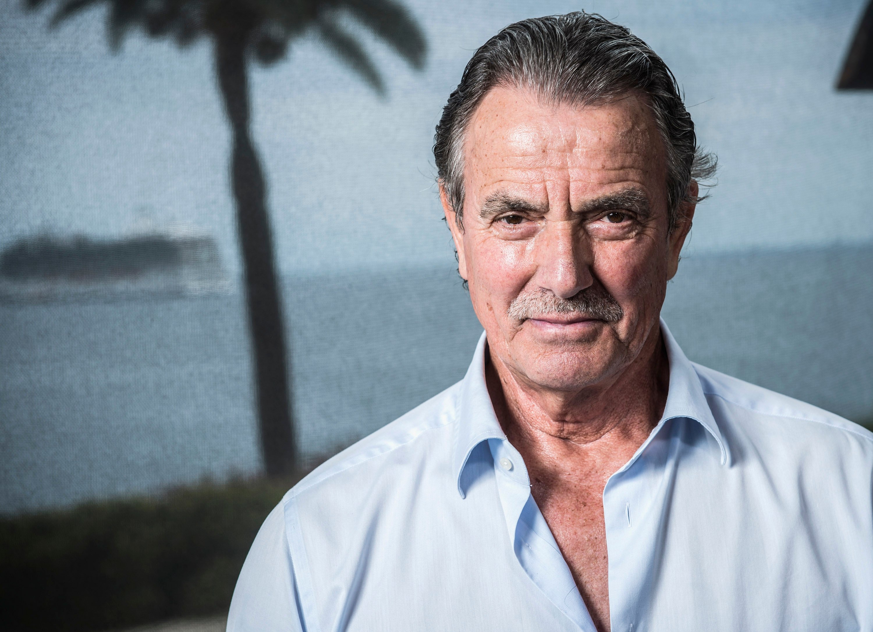 Eric Braeden in 2013 in front of trees and an ocean