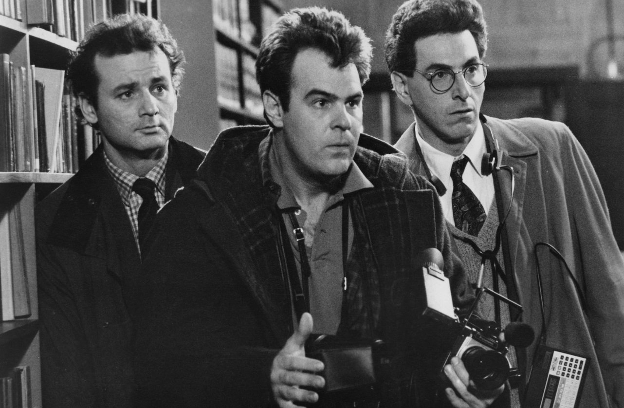 Bill Murray, Dan Aykroyd, and Harold Ramis stare off-camera in 'Ghostbusters'