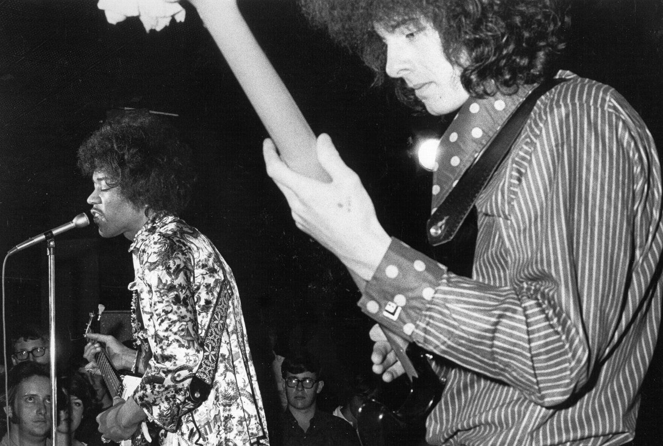 Jimi Hendrix sings and plays guitar while Noel Redding plays bass on stage
