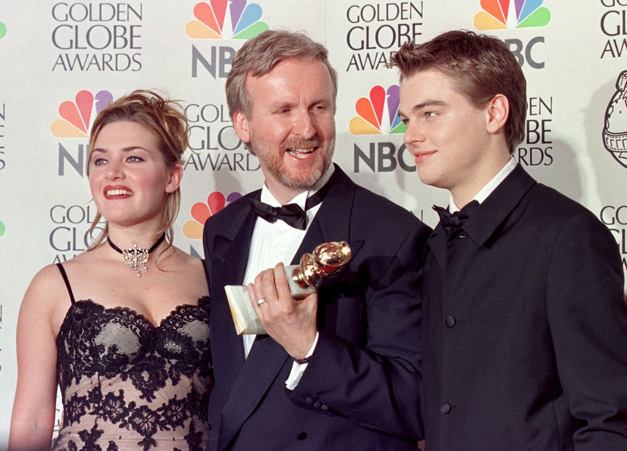 Director James Cameron(C) and actress Kate Winslet(L) and actor Leonardo DiCaprio(R) pose for photographers after Cameron won the award for Best Director for 'Titanic' at the 55th Annual Golden Globe Awards
