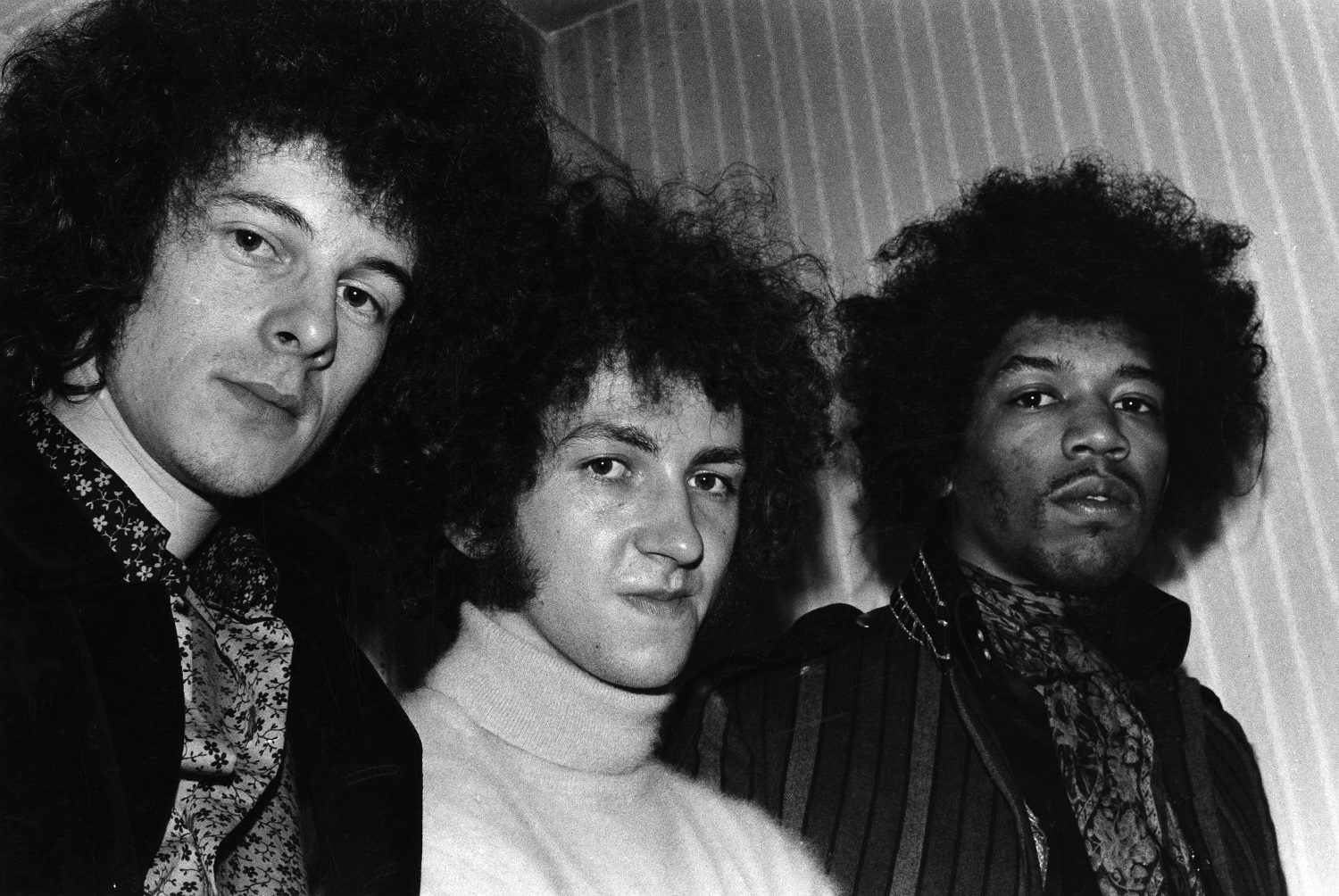 Jimi Hendrix poses for the camera with bandmates Mitch Mitchell and Noel Redding to his right, 1967