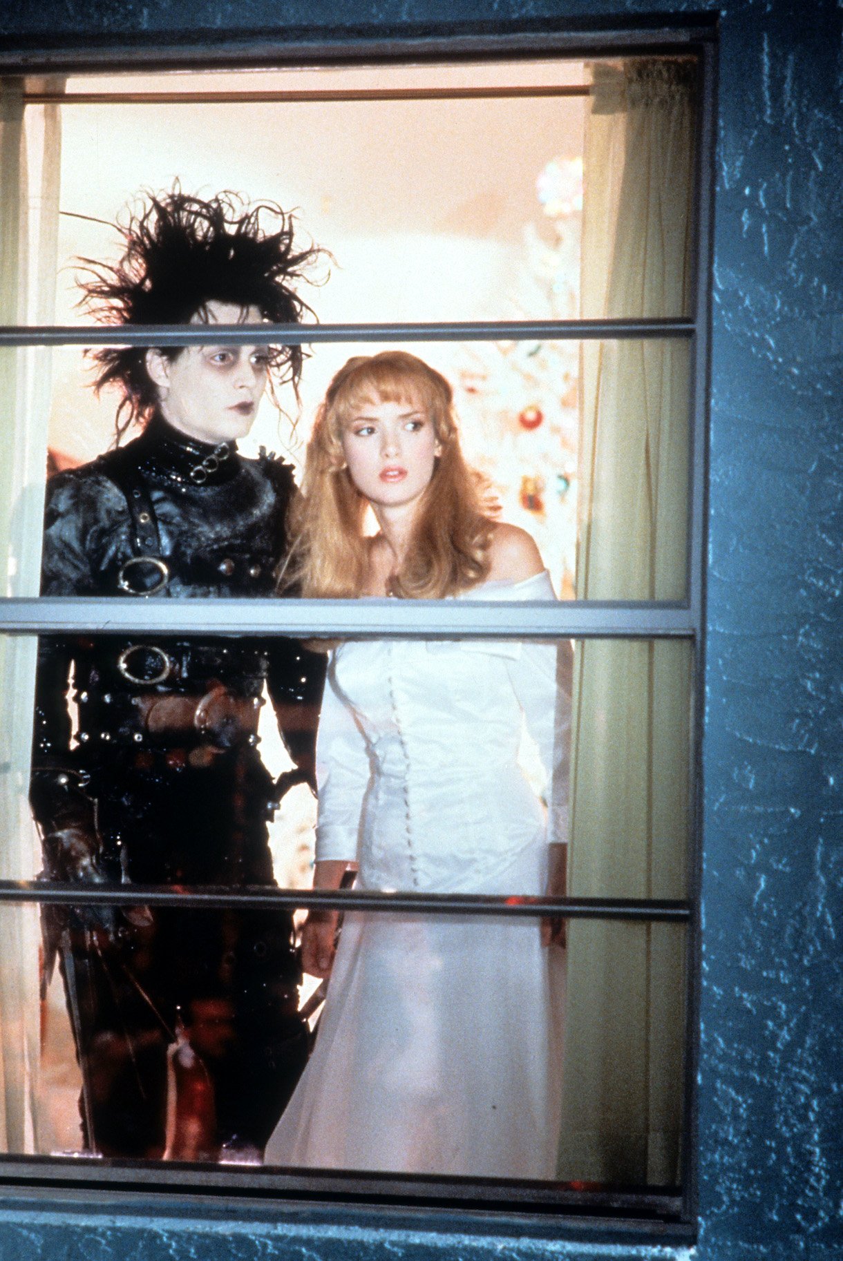 Johnny Depp and Winona Ryder looking out window in a scene from the film 'Edward Scissorhands', 1990