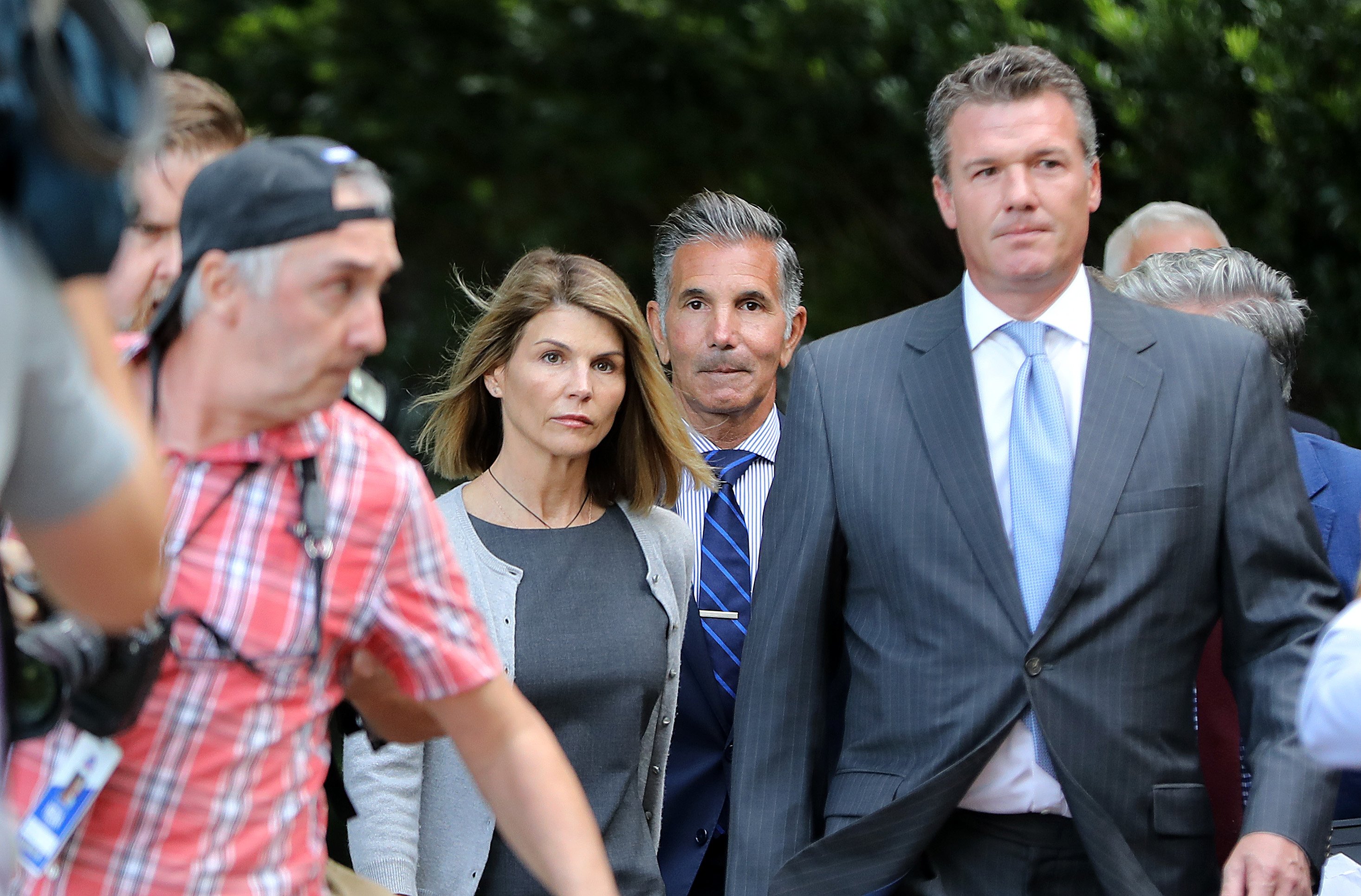 Lori Loughlin and Mossimo Giannulli surrounded by lawyers and reporters outside courthouse