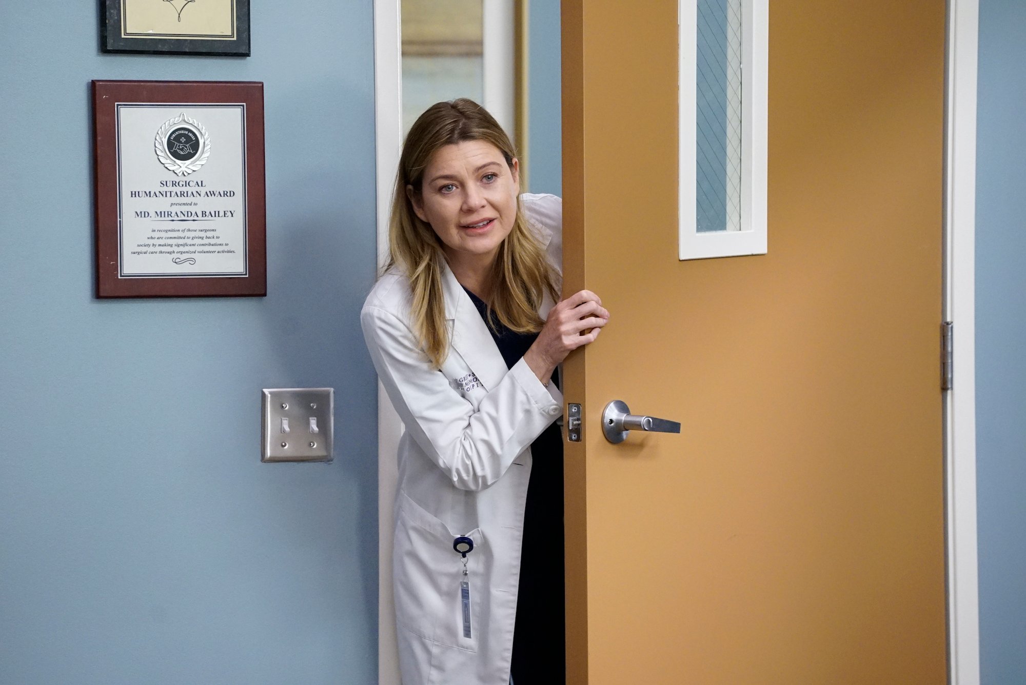 ELLEN POMPEO, as Meredith Grey, opens a door.