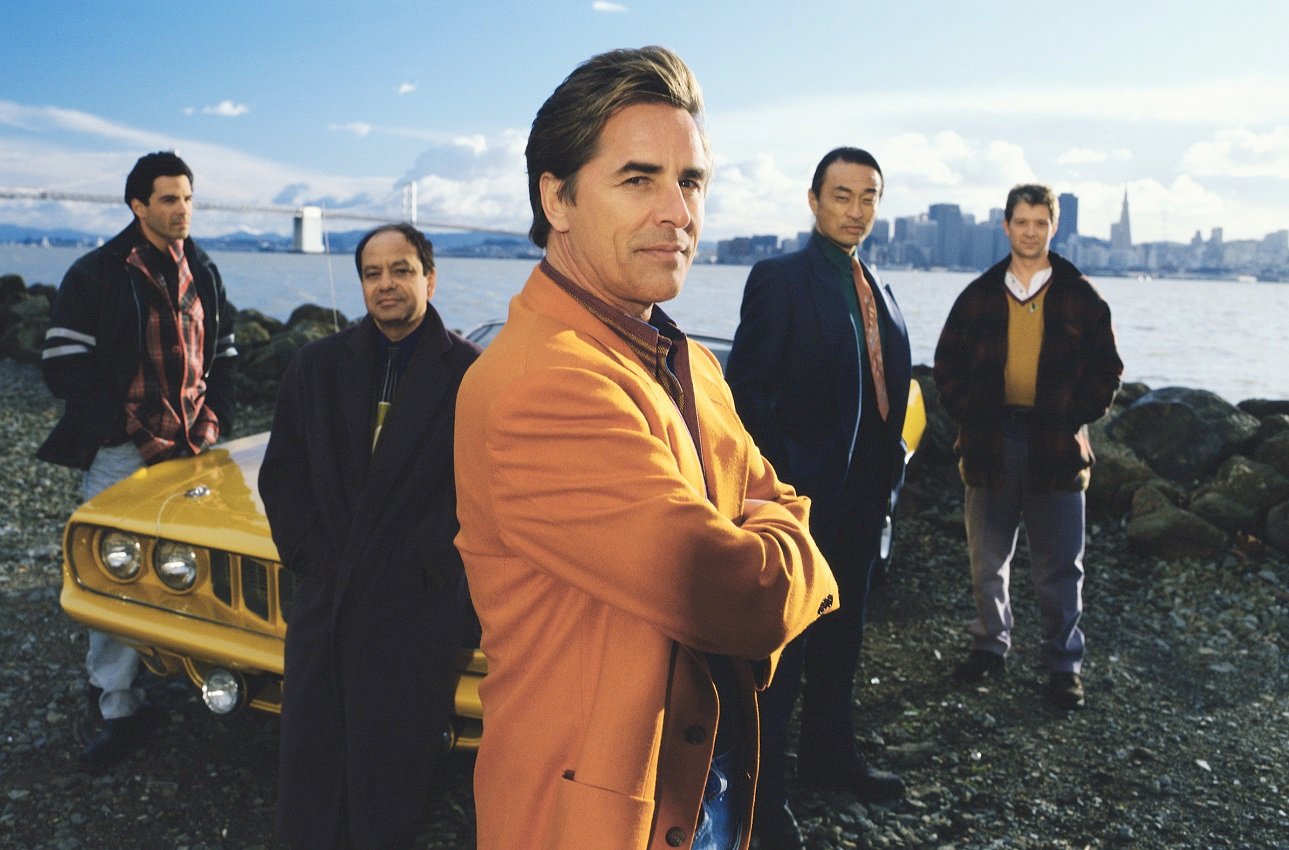 Don Johnson stands with the cast of 'Nash Bridges' with a view of San Francisco behind him