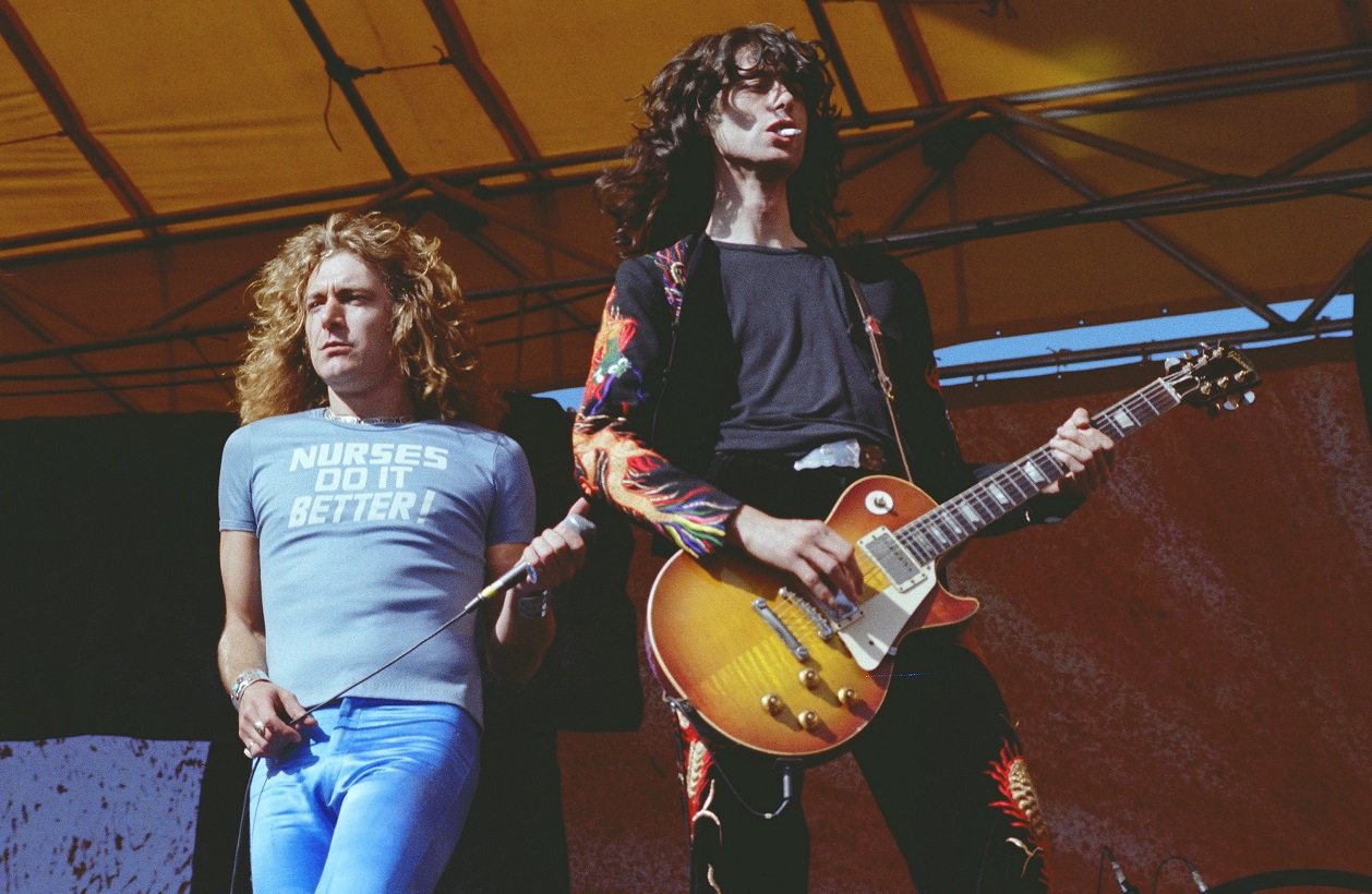 Robert Plant holds a microphone while Jimmy Page plays guitar at a Led Zeppelin concert