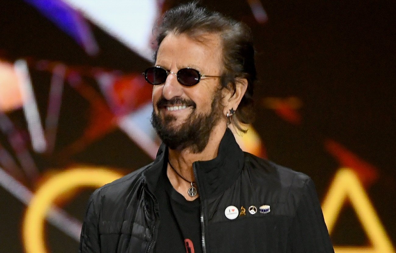 Ringo Starr, wearing sunglasses, smiles during a presentation at the 2021 Grammys