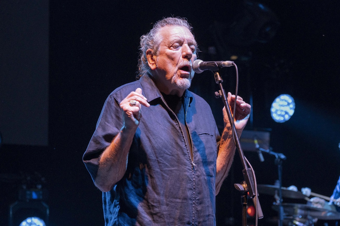 Robert Plant sings into a microphone on stage in 2019