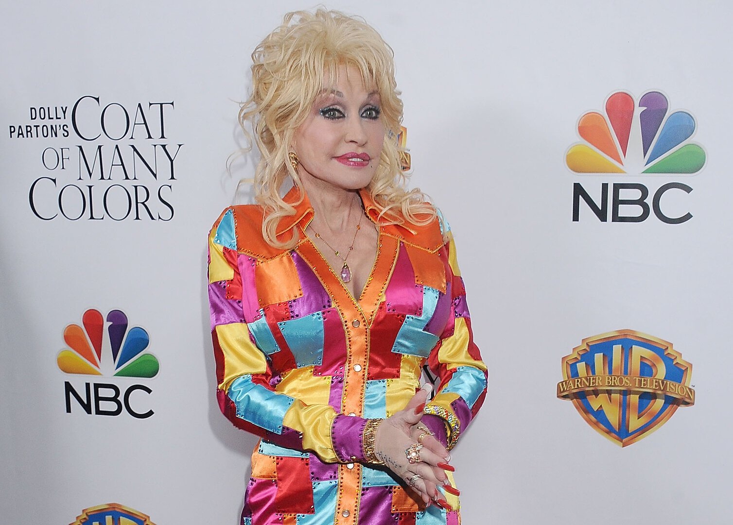 Dolly Parton at the Premiere Of Warner Bros. Television's "Dolly Parton's Coat Of Many Colors" in a multi-colored coat dress.