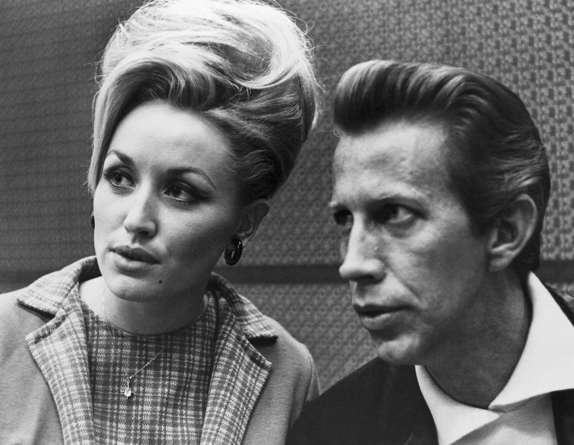 Dolly Parton and Porter Wagoner in black and white. They're both looking to the right of the camera, appearing contemplative. The year is 1968.