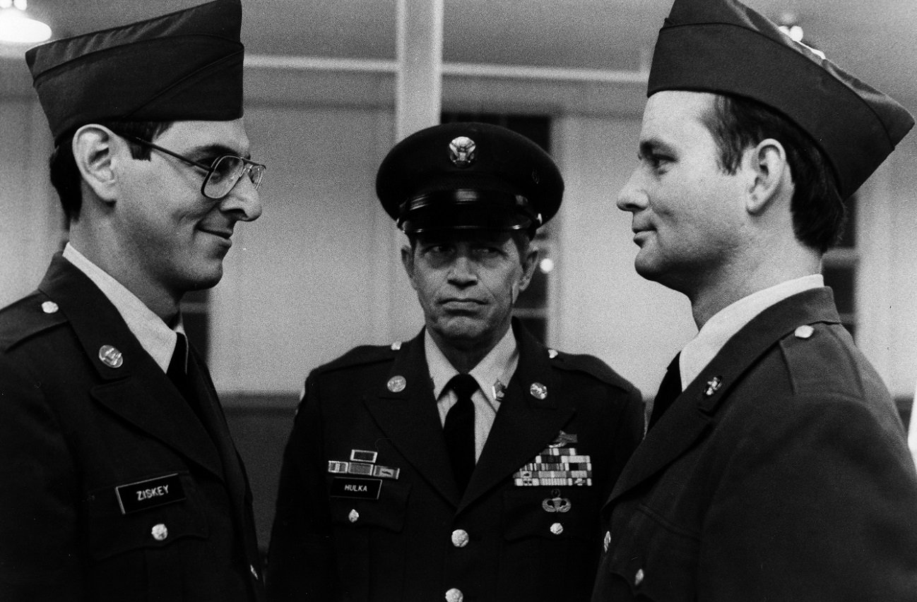 Harold Ramis and Bill Murray smirk at each other in army uniform in 'Stripes'