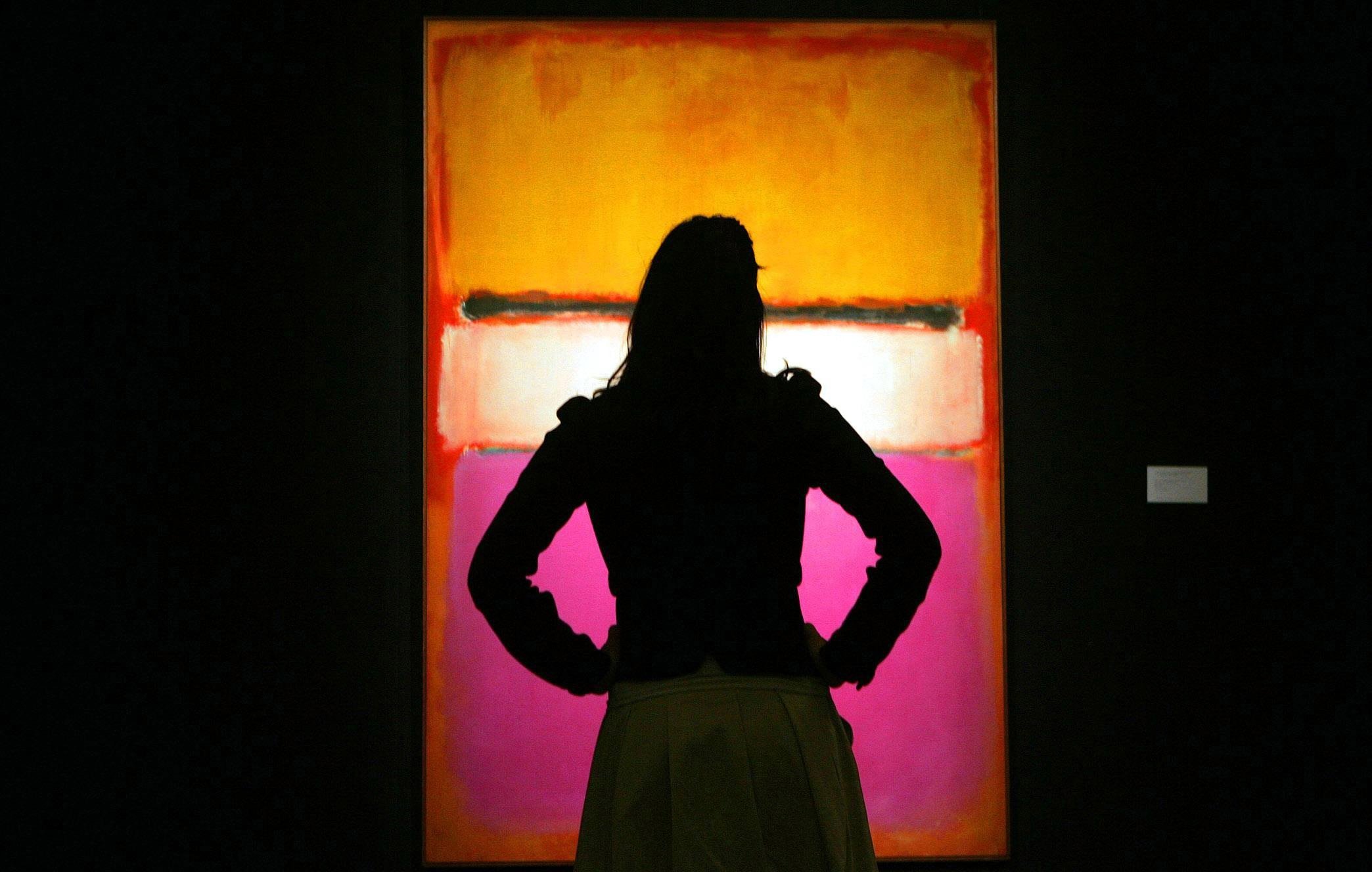 A person in silhouette looks at a the Mark Rothko painting White Center (Yellow, Pink and Lavender on Rose)