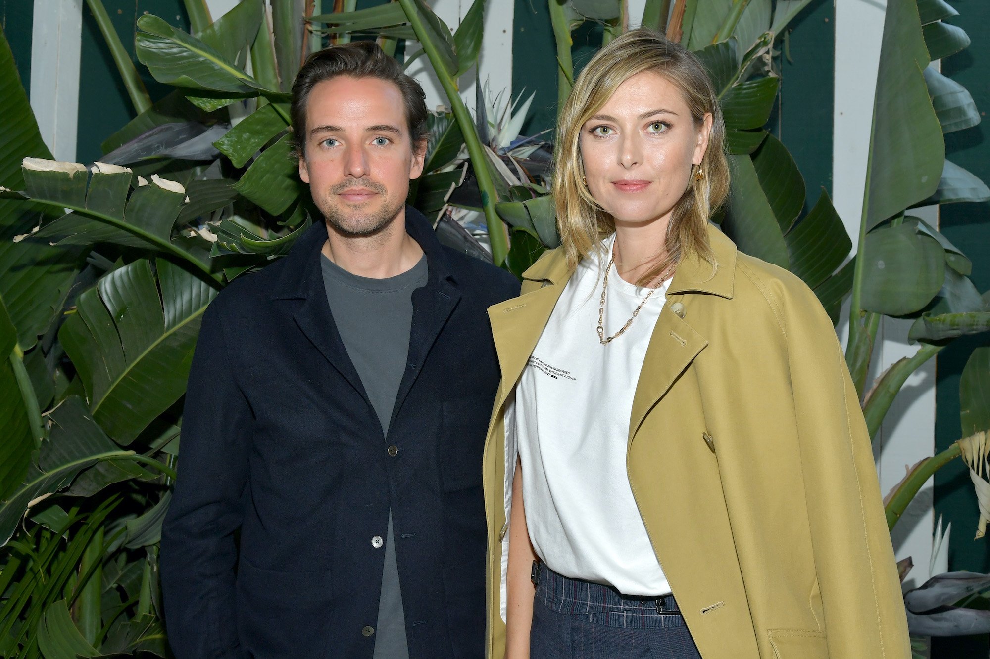 (L-R) Alexander Gilkes and Maria Sharapova smiling in front of a plant